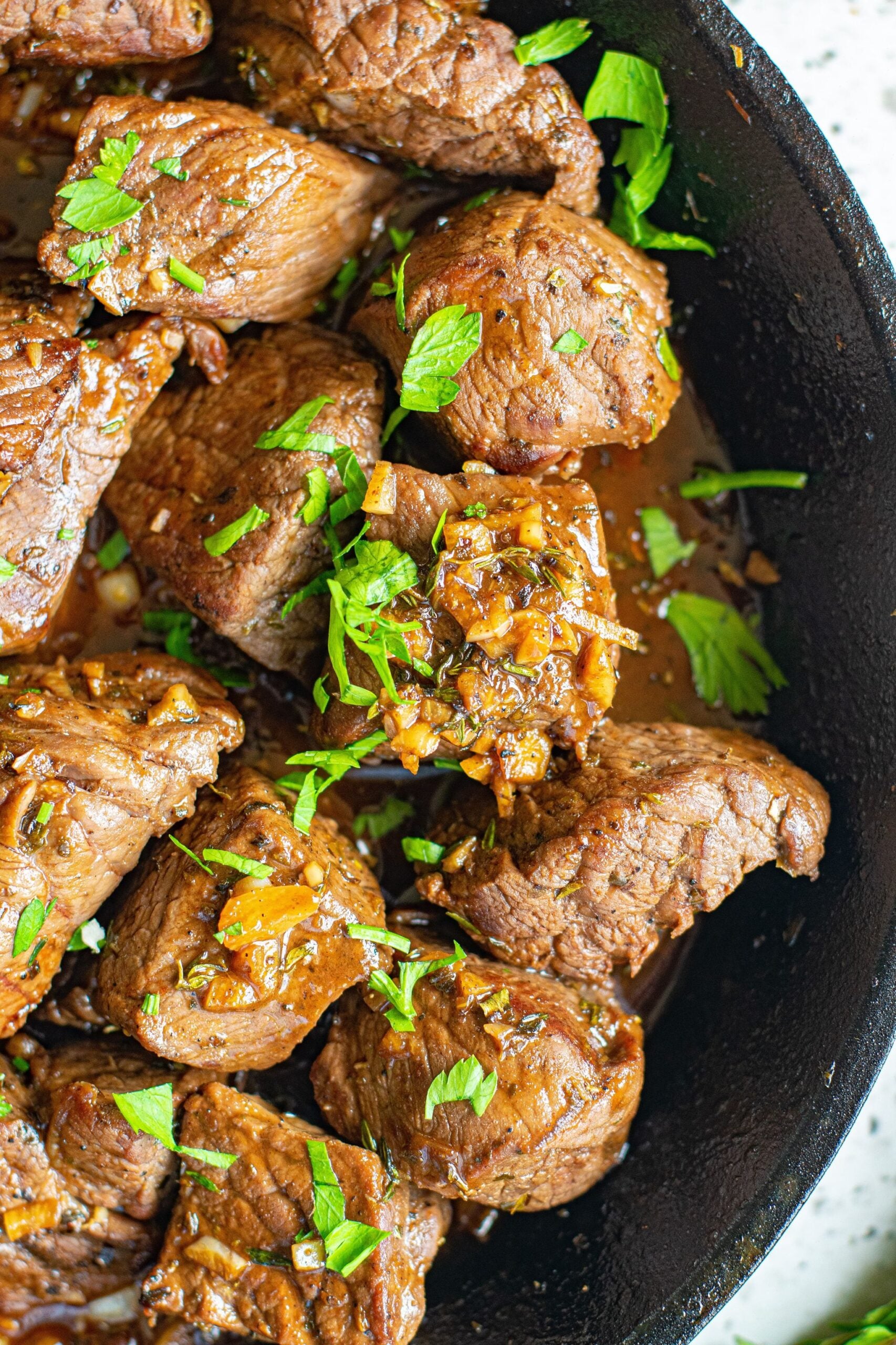 Close up view of Garlic Honey Steak Bites in a cast iron skillet.