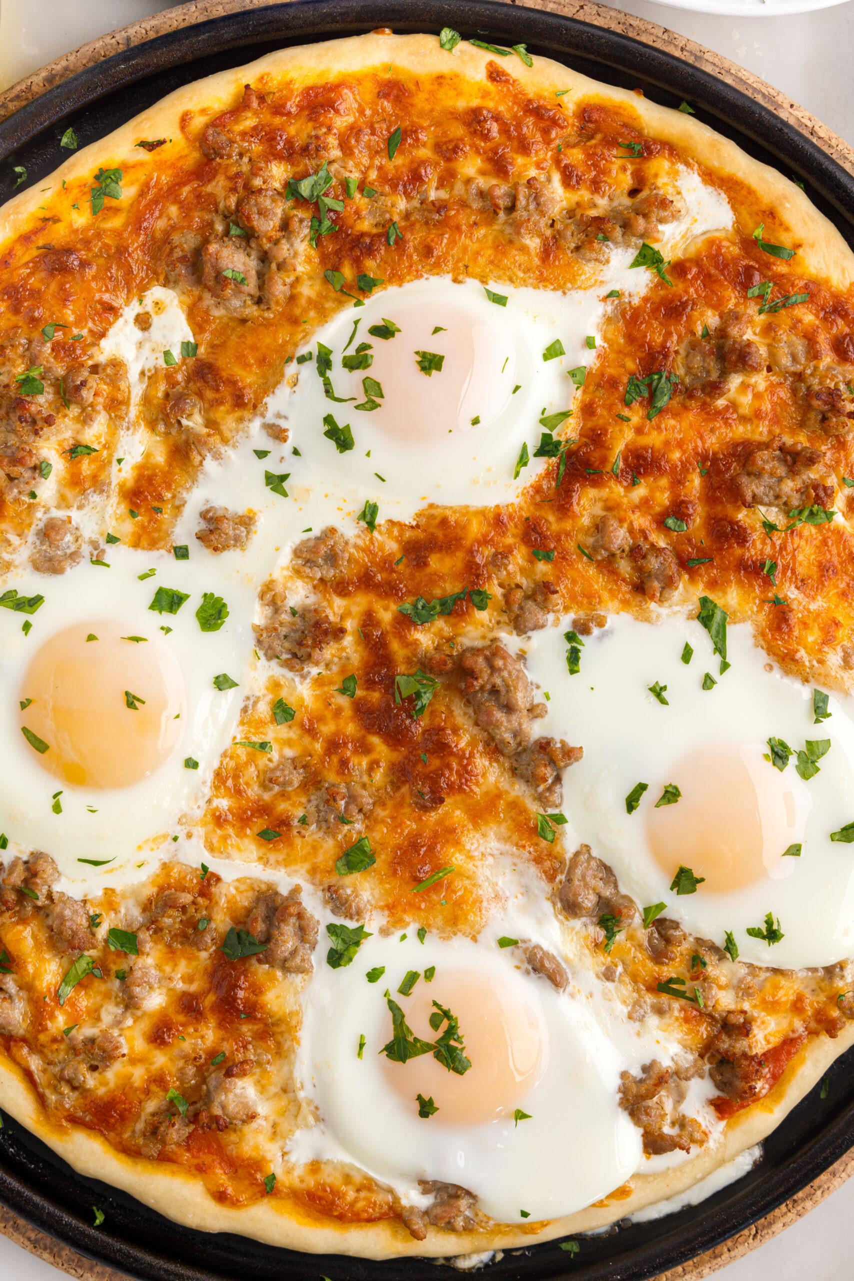 Overhead view of Breakfast Pizza on a black pizza dish.