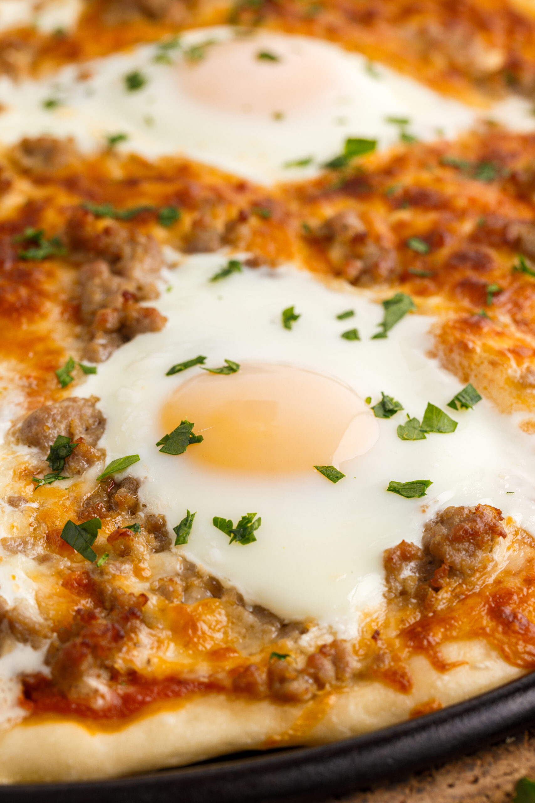 Close up view of Breakfast Pizza on a black pizza dish.