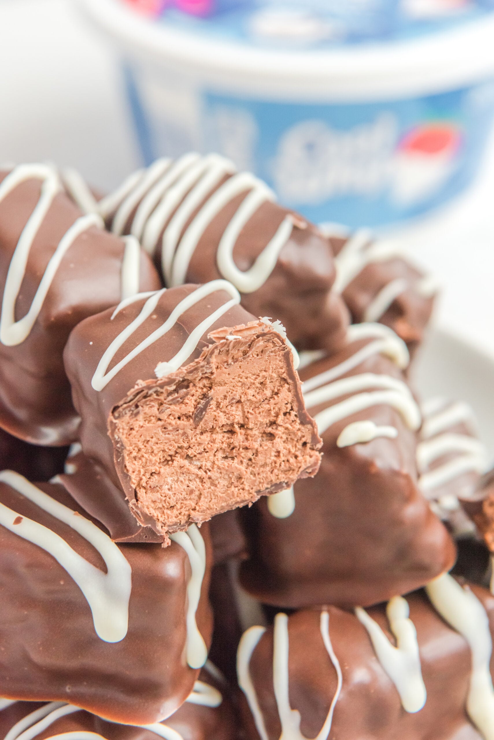 Close up view of half a bar of Cool Whip Candy on top of a stack of candy bars.