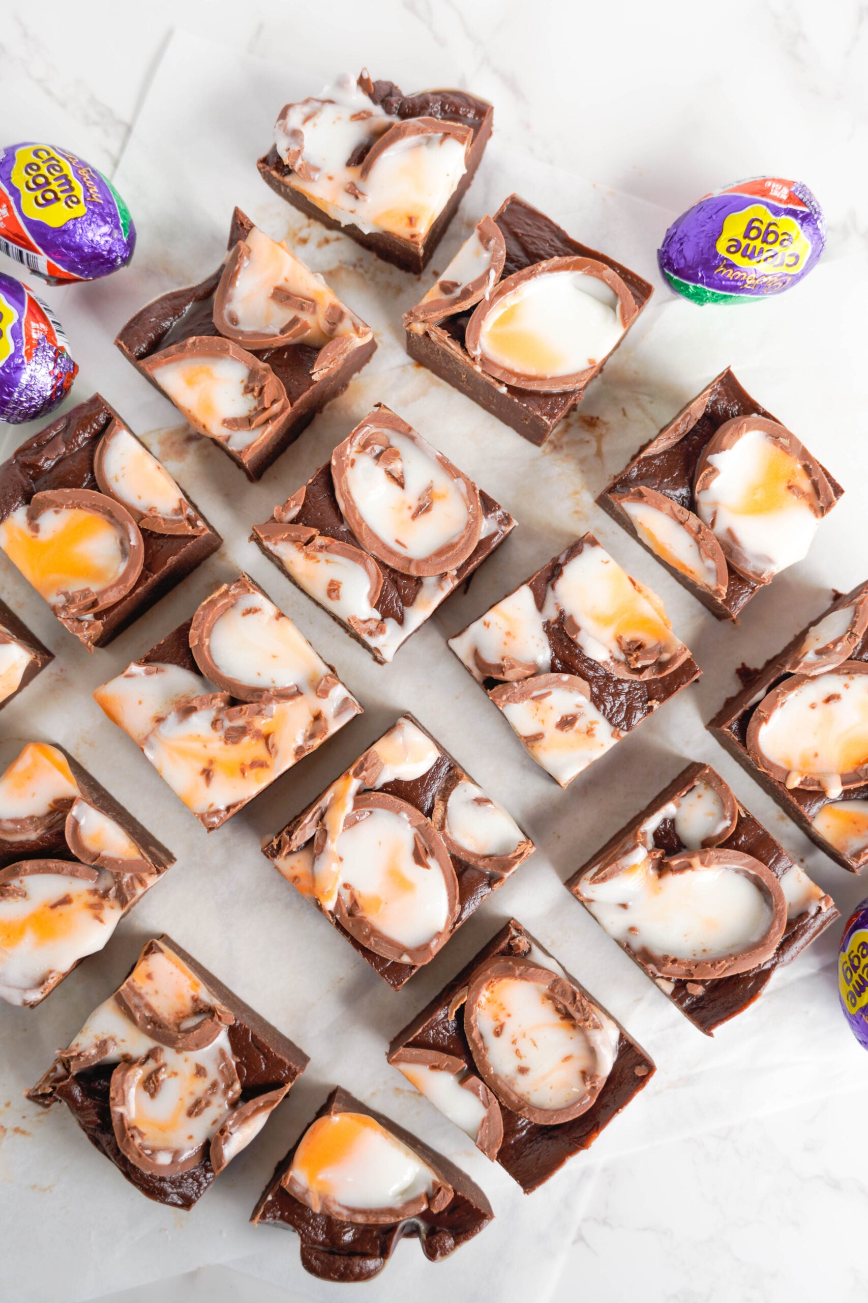 Overhead view of Cadbury Cream Fudge on a piece of parchment paper.