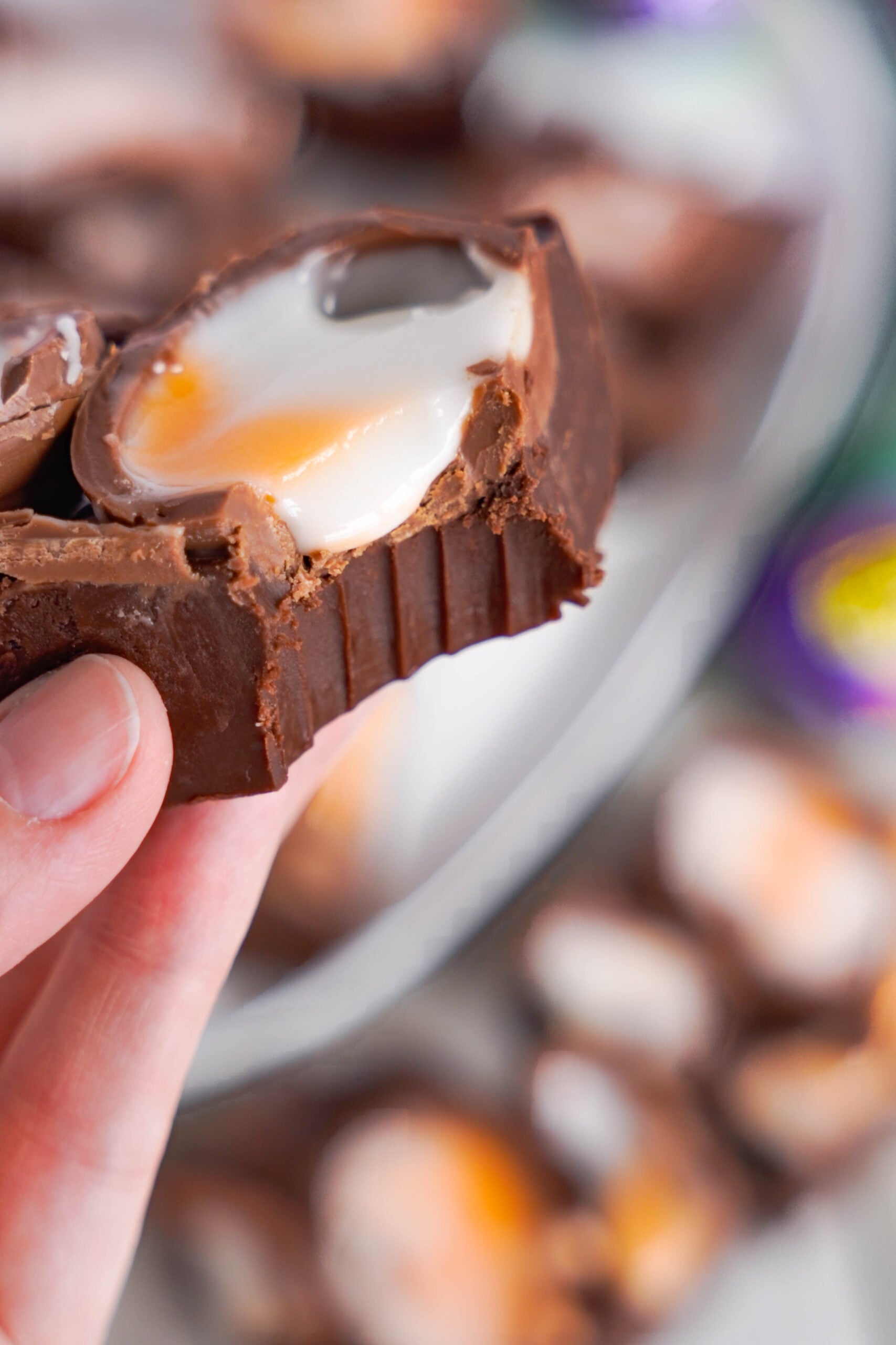 Close up view of a piece of Cadbury Cream Fudge with a bite removed.