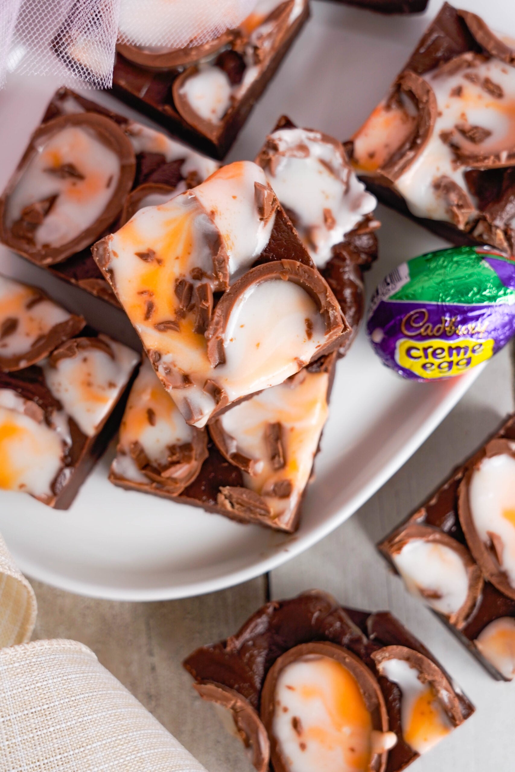 Overhead view of Cadbury Cream Fudge stacked on a white dish.