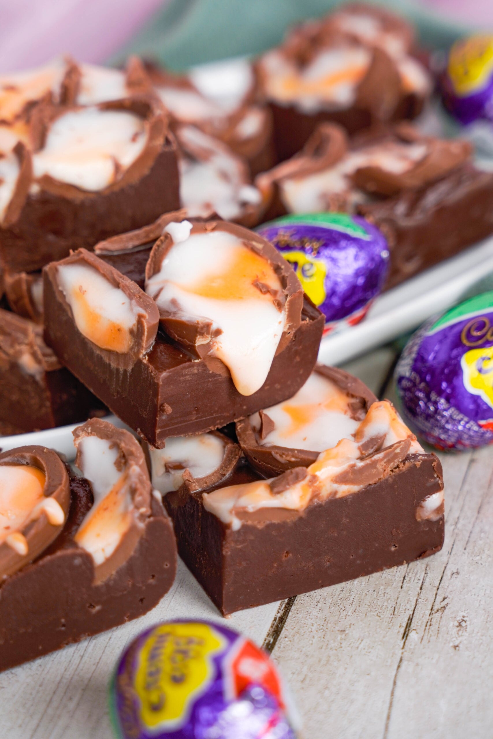 Front view of Cadbury Cream Fudge stacked on a white dish.