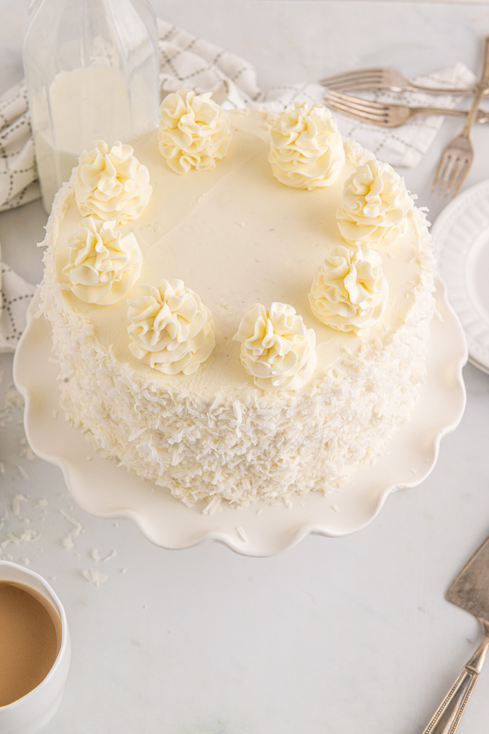 Overhead view of Coconut Layer Cake on a white cake stand.