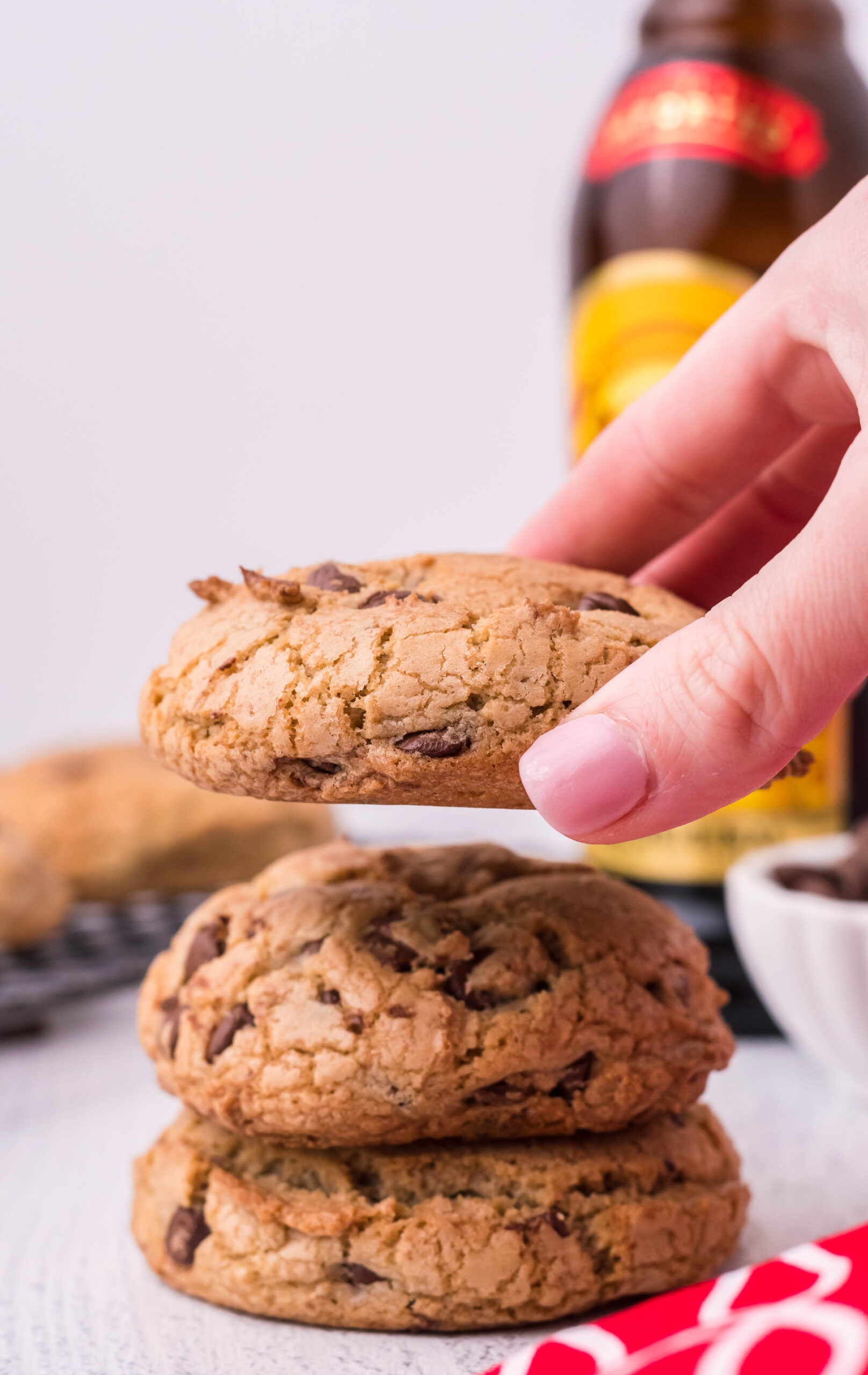 Front view of two Kahlua Cookies stacked and a person's hand holding a single cookie.