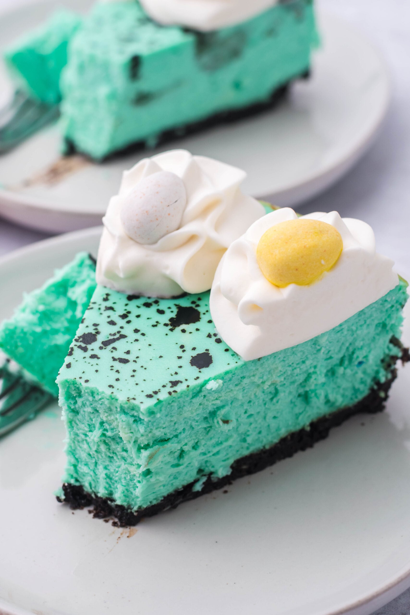 Side view of a slice of Speckled Egg Cheesecake with a bite removed by a silver fork.