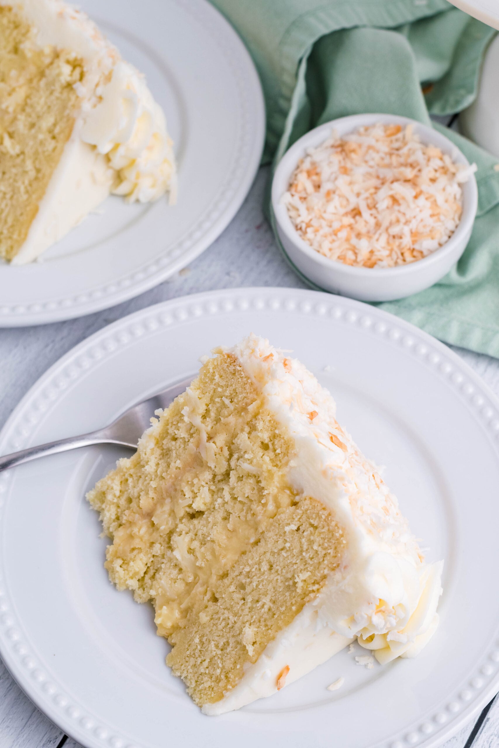 Overhead view of a slice of Coconut Custard Cake on a white plate.