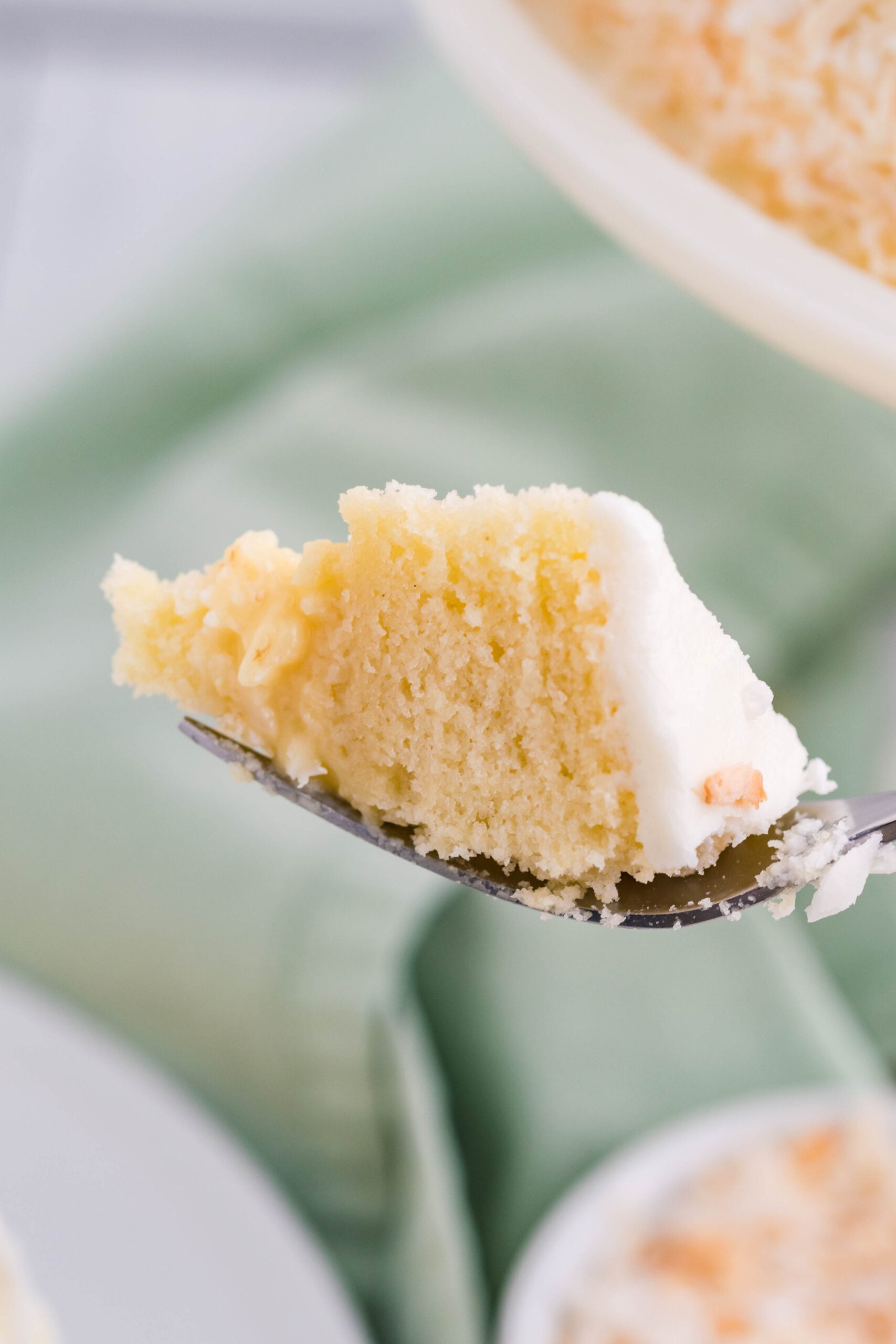 Front view of a bite of Coconut Custard Cake on a silver fork.