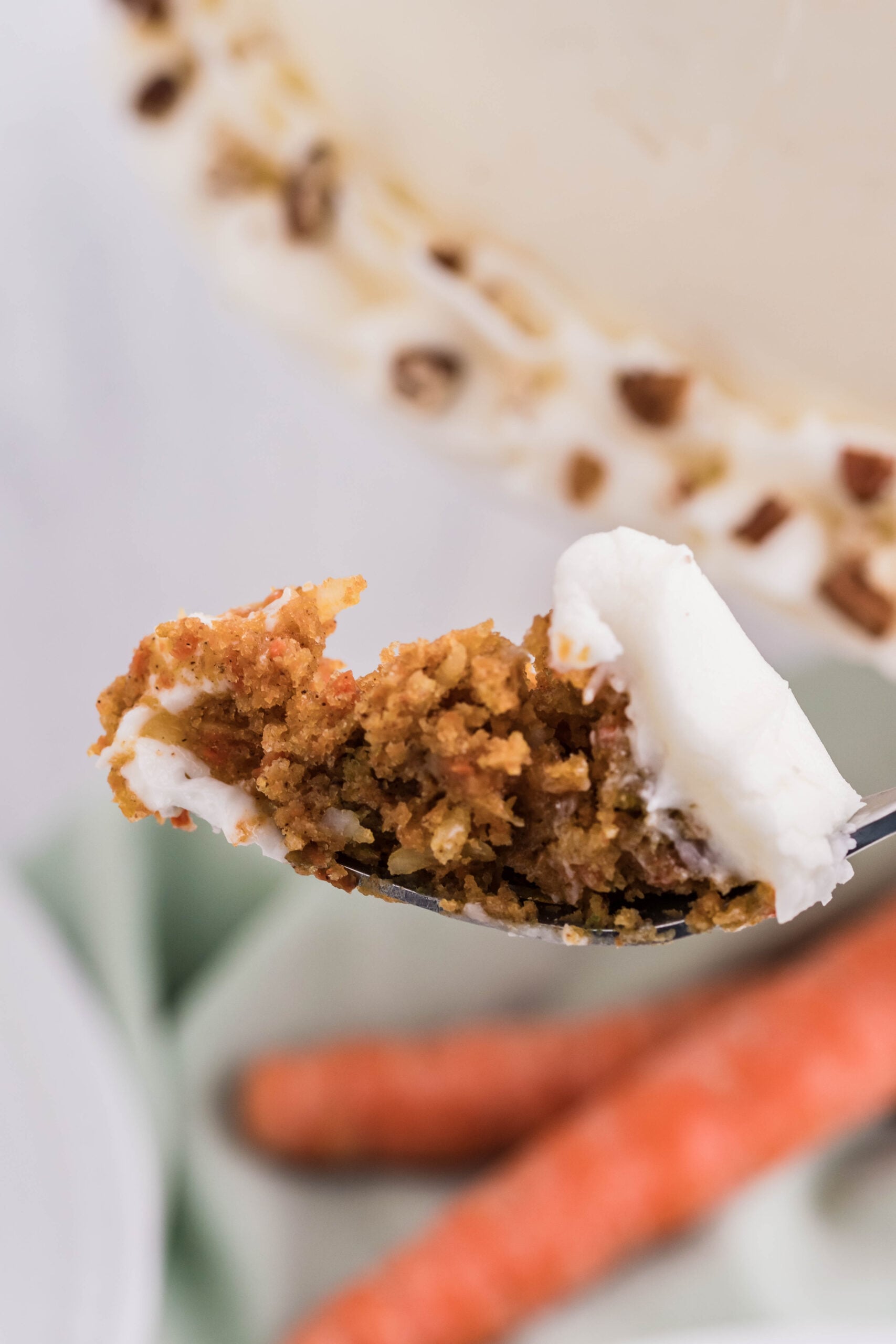 Side view of a bite of Carrot Cake on a silver fork.