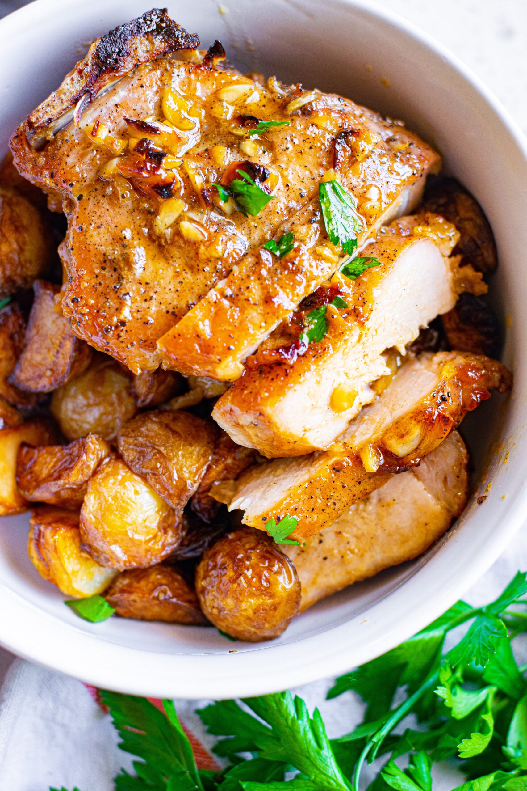 Close up view of Honey Garlic Pork Chops cut into strips and served over potatoes.