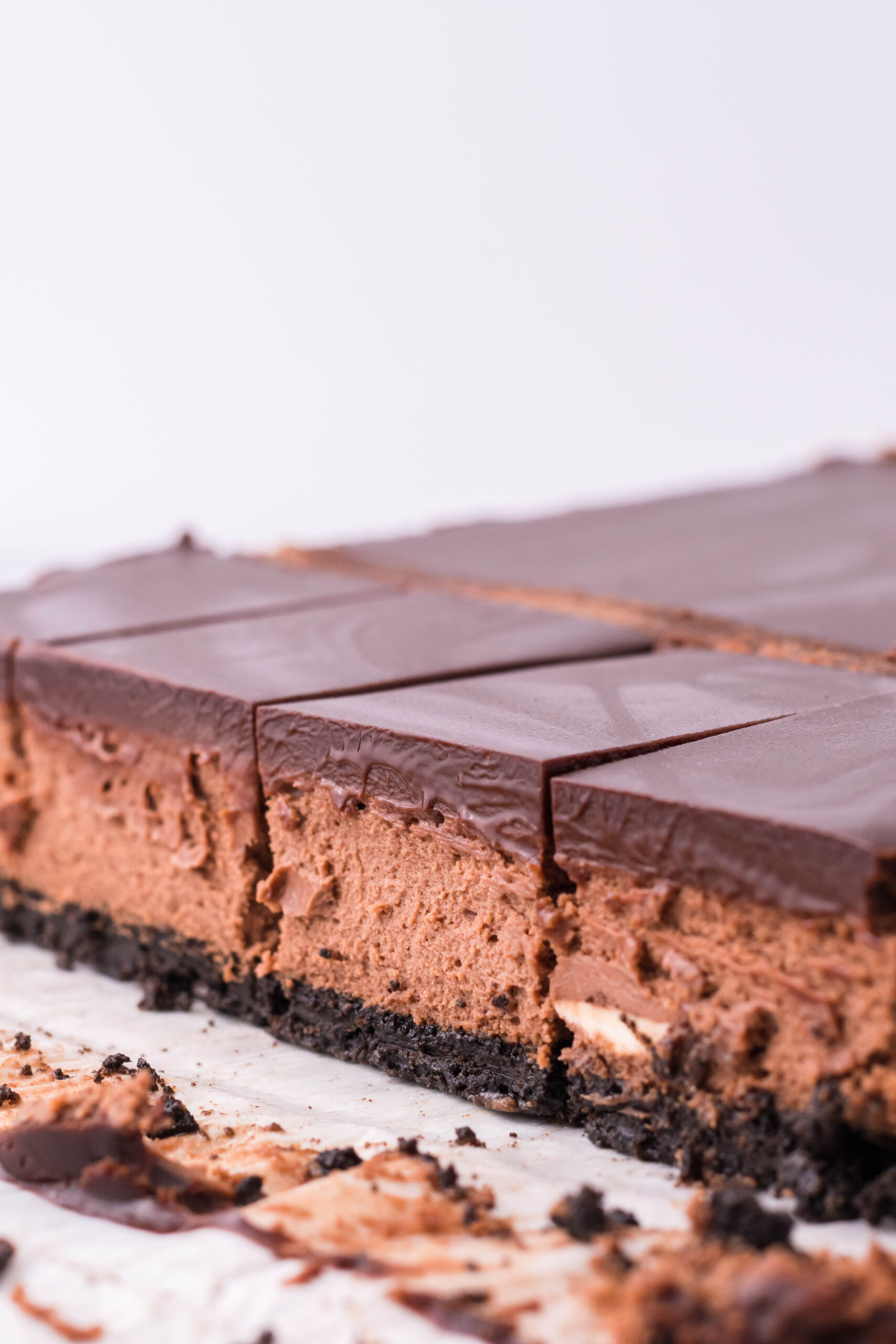 Side view of the three layers of the chocolate cheesecake bars.