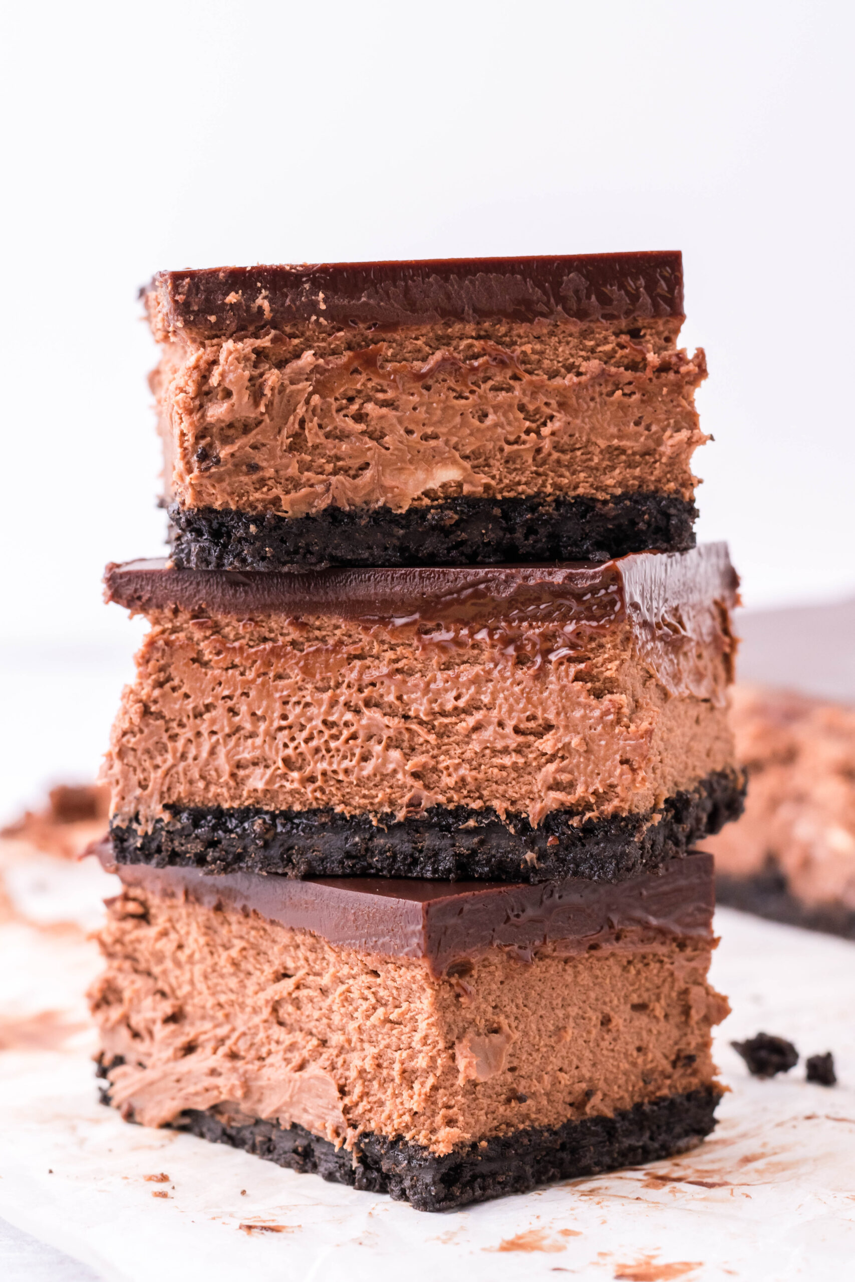 Three bars of chocolate cheesecake stacked on top of each other. 