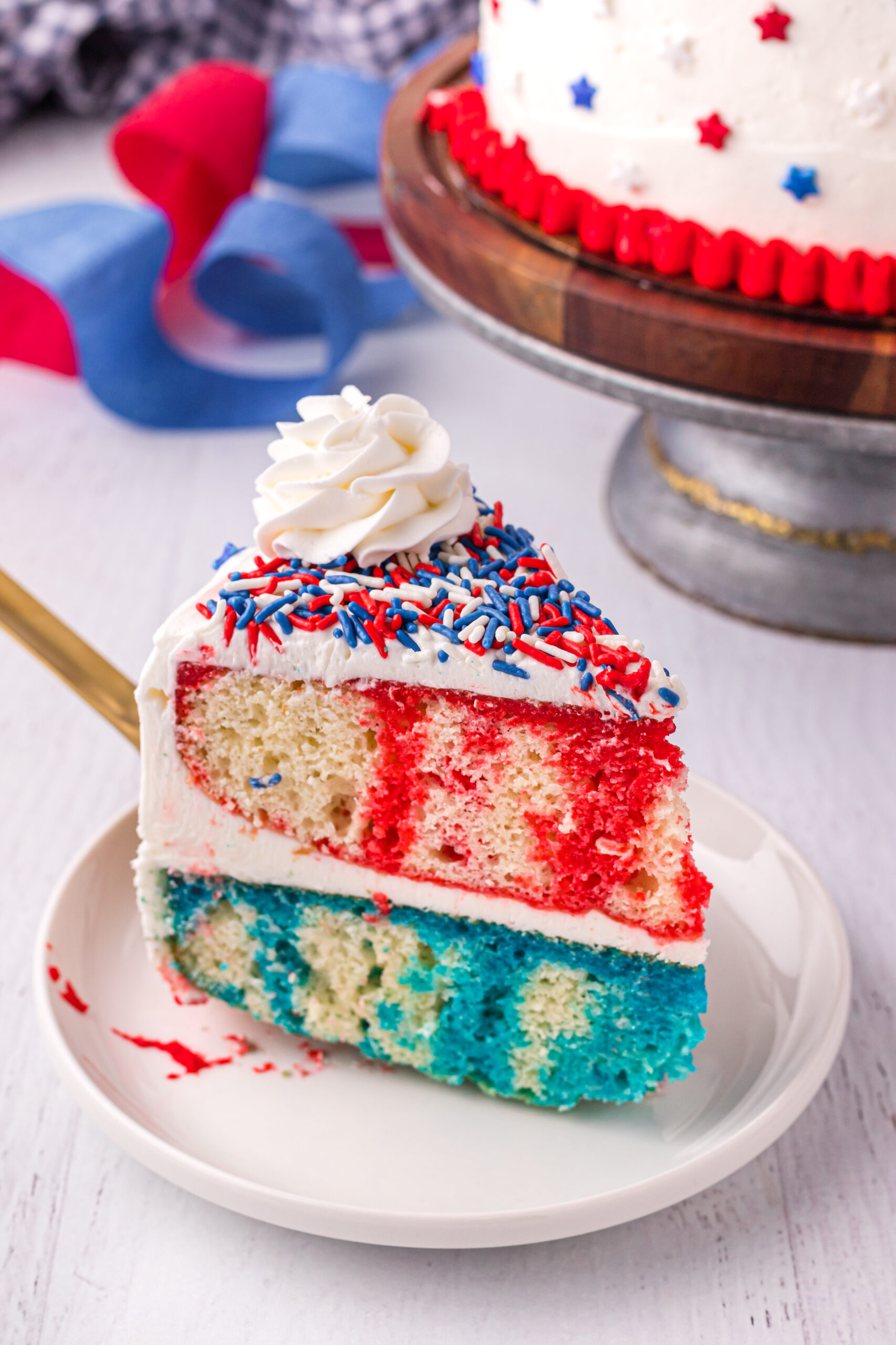 Front view of a slice of 4th of July Cake on a white plate.