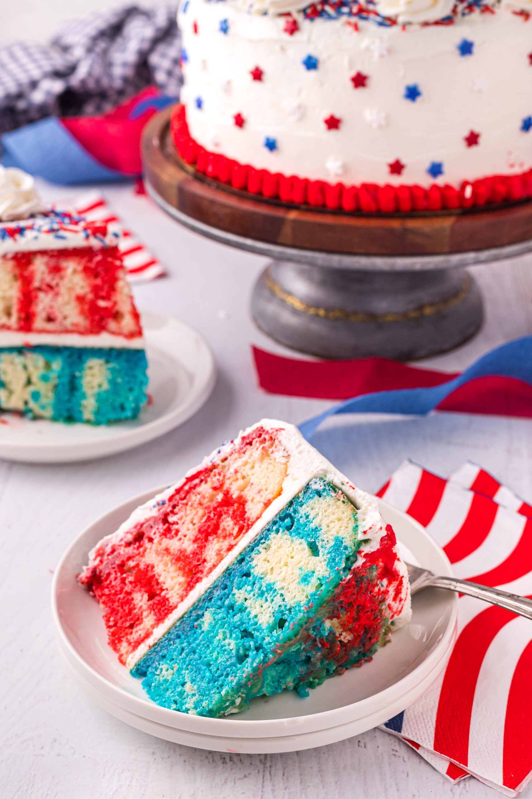 Front view of a slice of 4th of July Cake on a white plate.