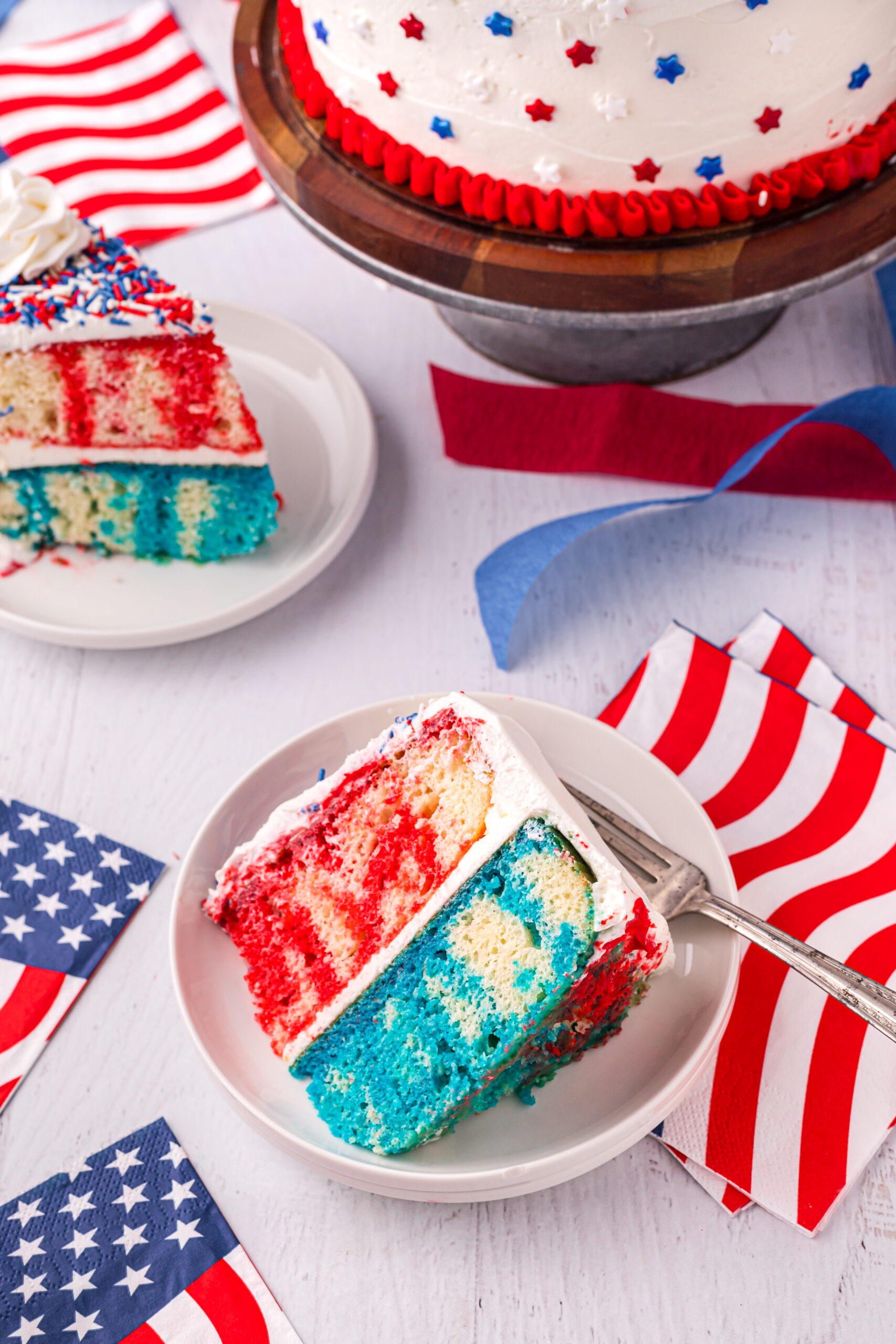Overhead view of a slice of 4th of July Cake on a white plate.