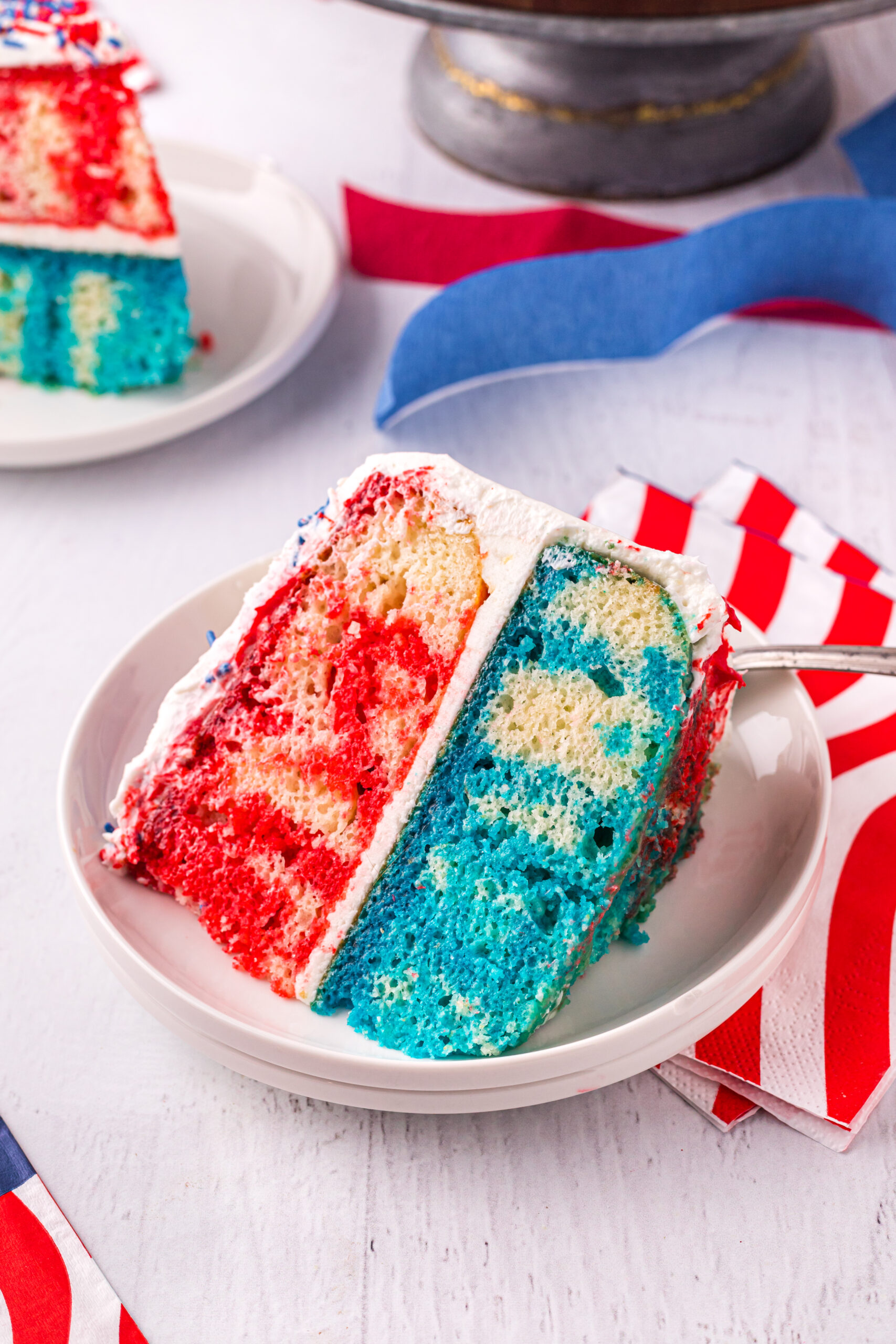 Front view of a slice of 4th of July Cake on a white plate.