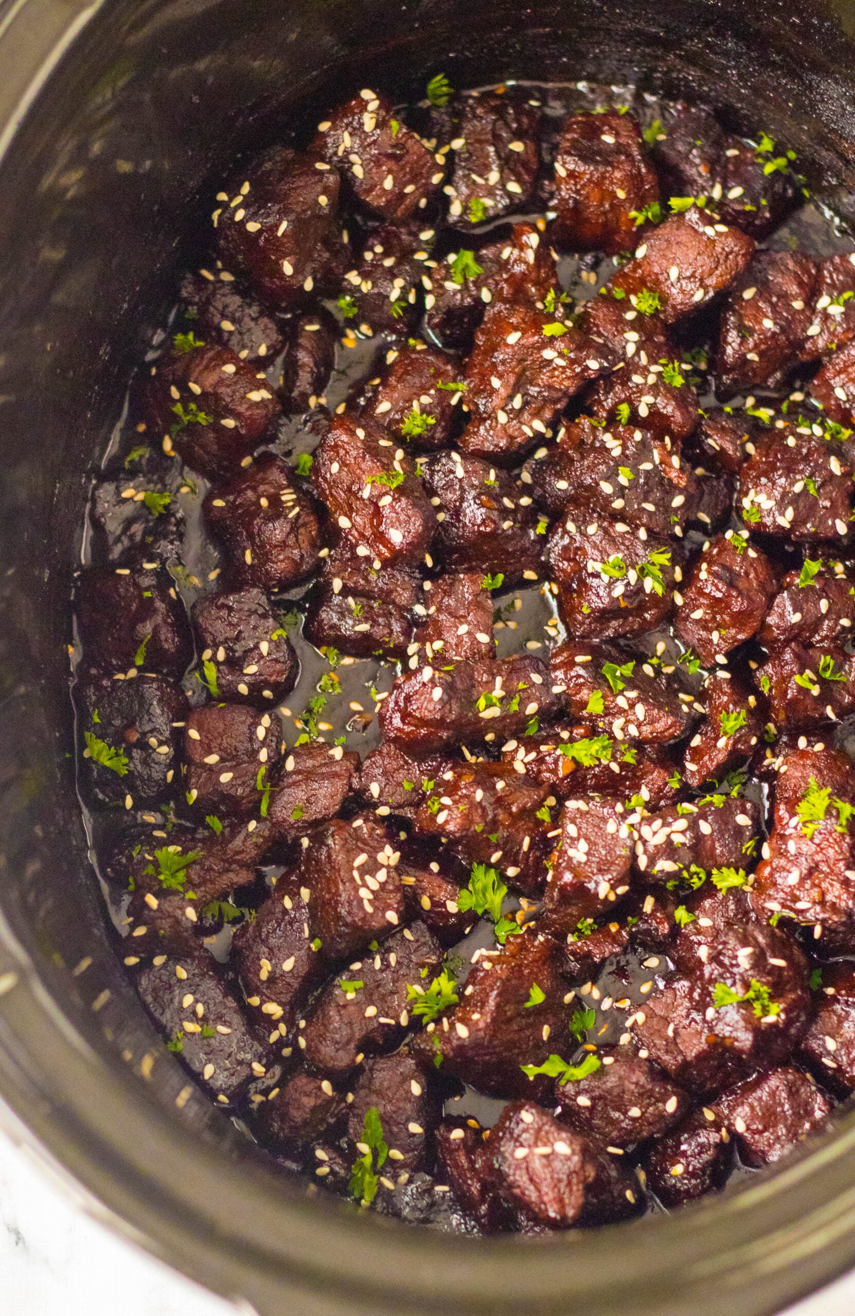 Overhead view of Slow Cooker Honey Garlic Steak Bites in a crock pot.