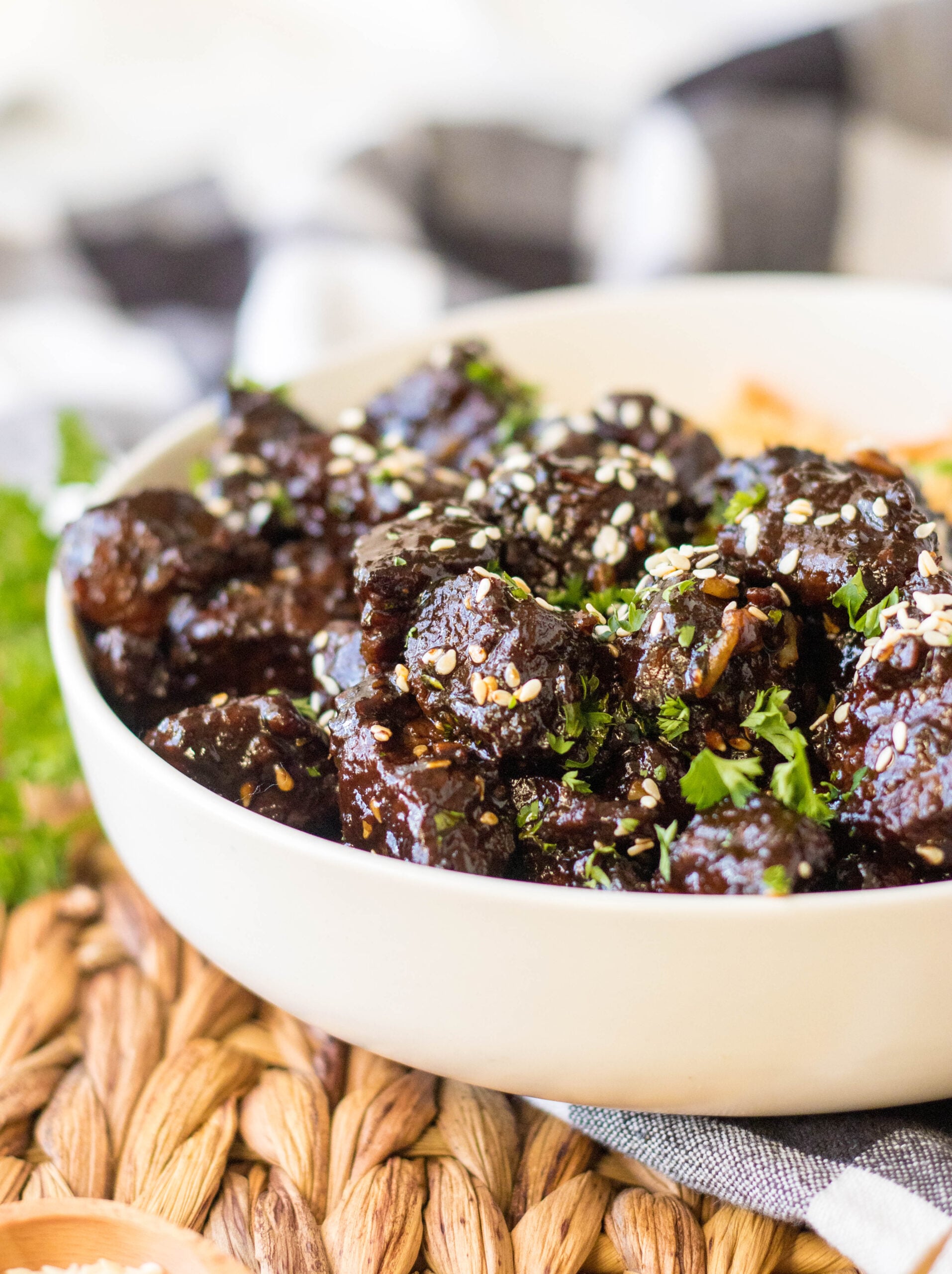 Close up view of Slow Cooker Honey Garlic Steak Bites in a white bowl served with fried rice.