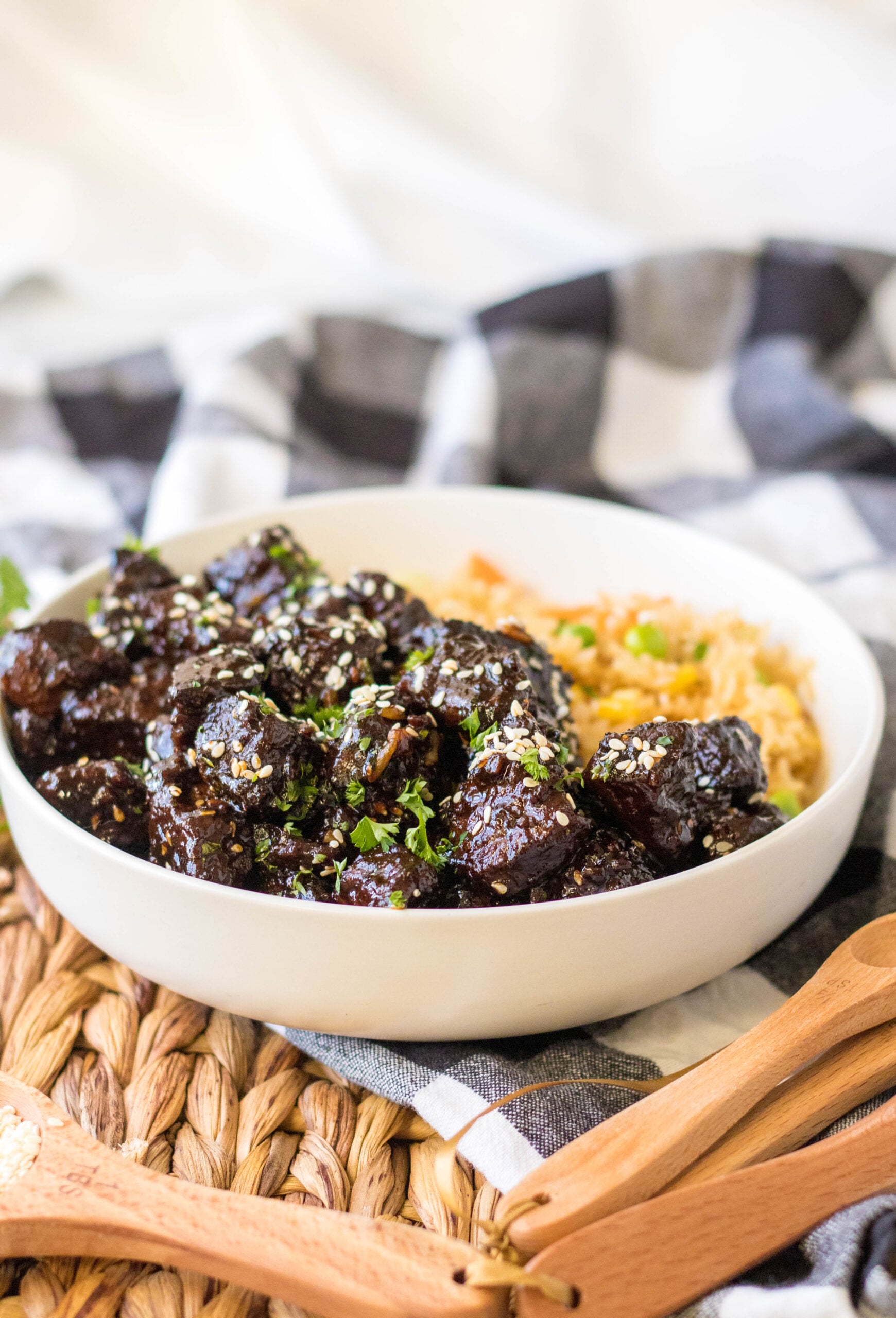 Front view of Slow Cooker Honey Garlic Steak Bites in a white bowl served with fried rice.