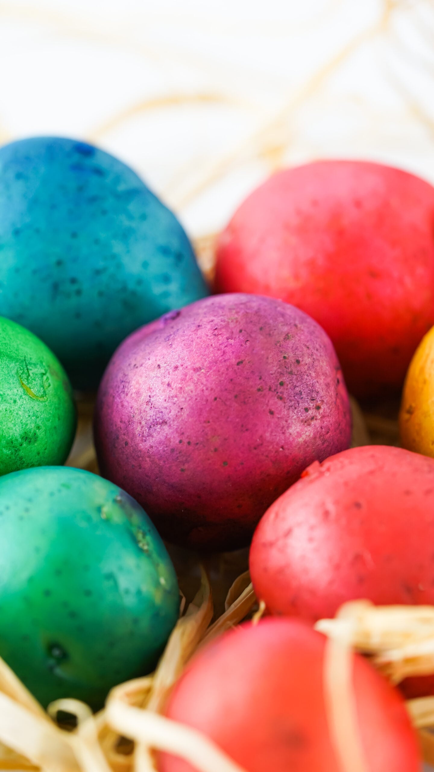 Close up view of Dyed Easter Egg Potatoes on a bed of straw.