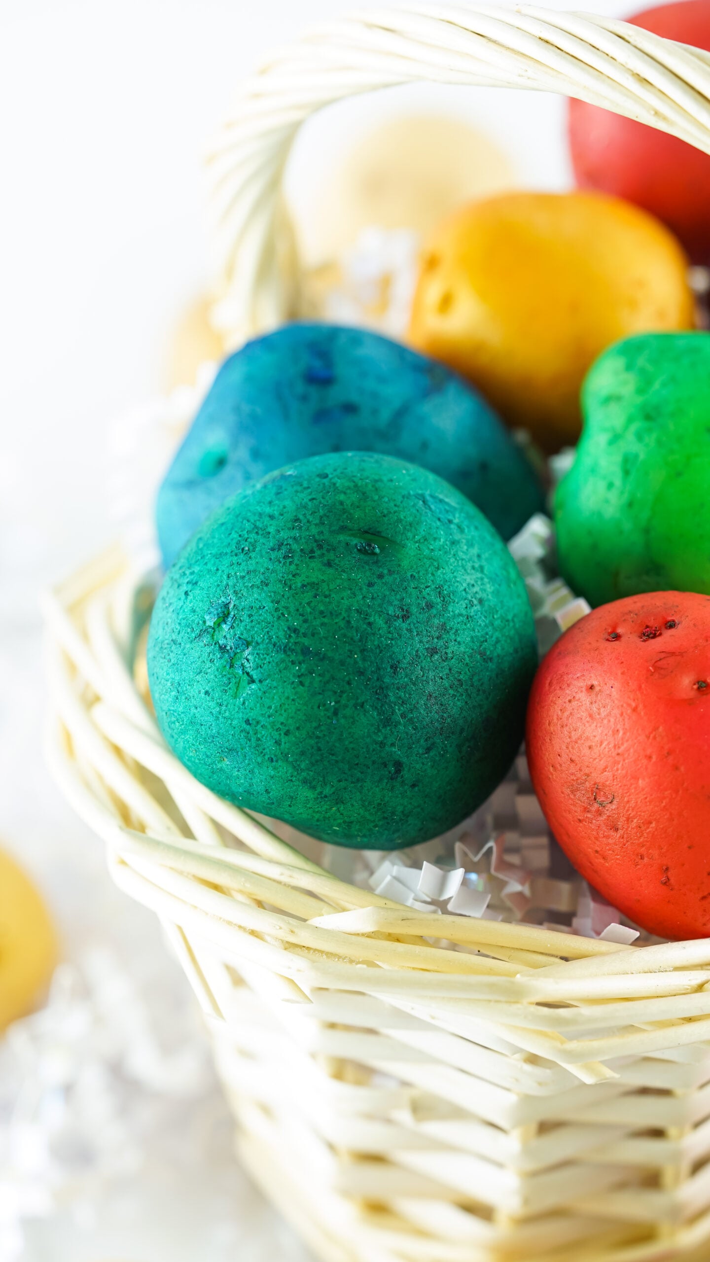 Front view of Dyed Easter Egg Potatoes in a tan basket.