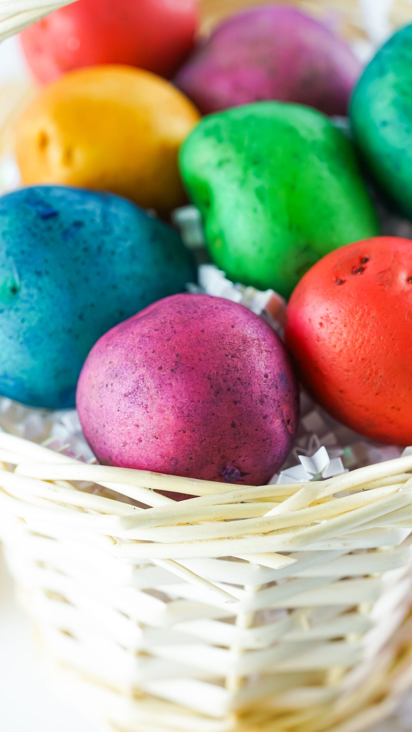 Close up view of Dyed Easter Egg Potatoes in a tan basket.