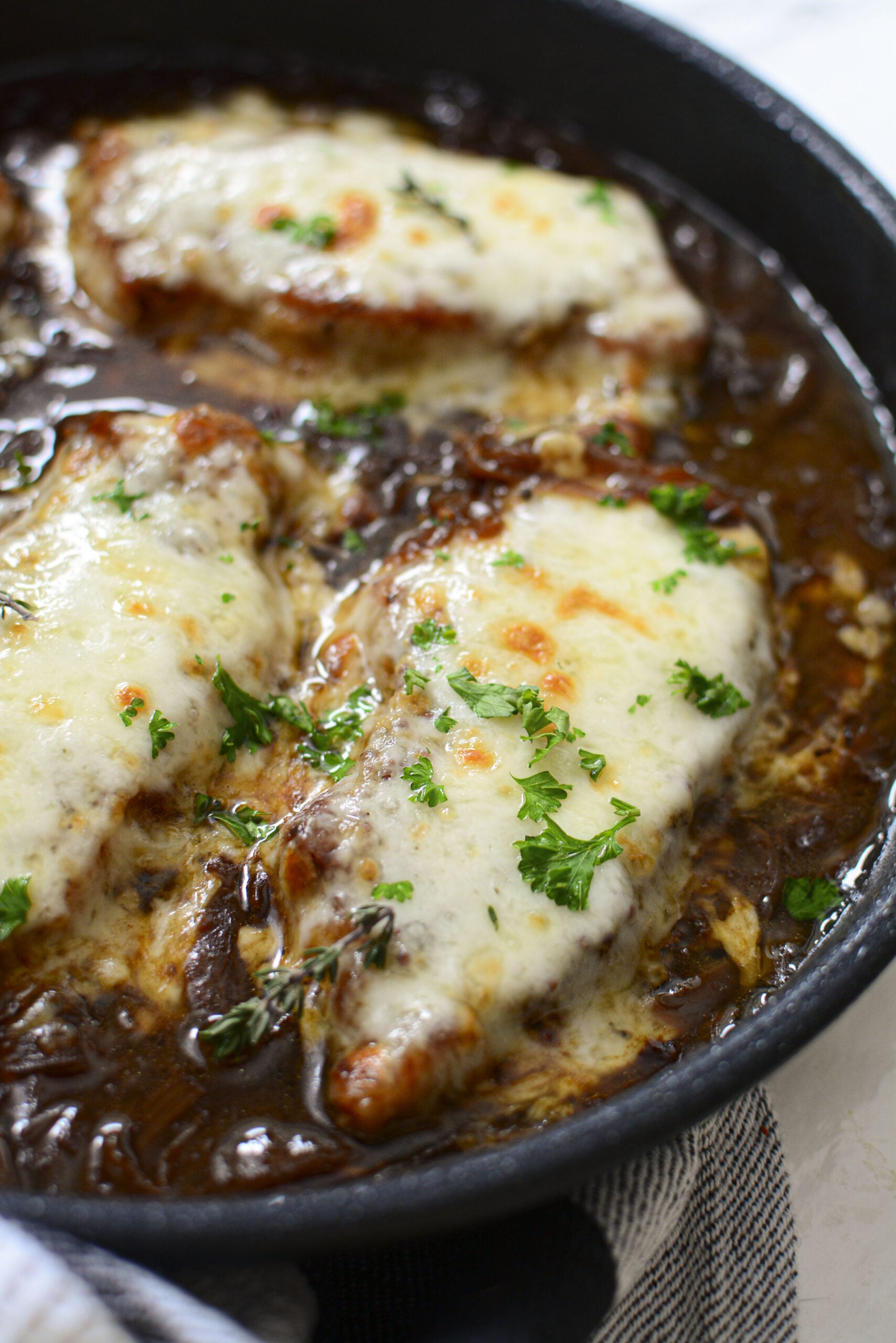 Close up view of French Onion Pork Chops in a cast iron skillet.