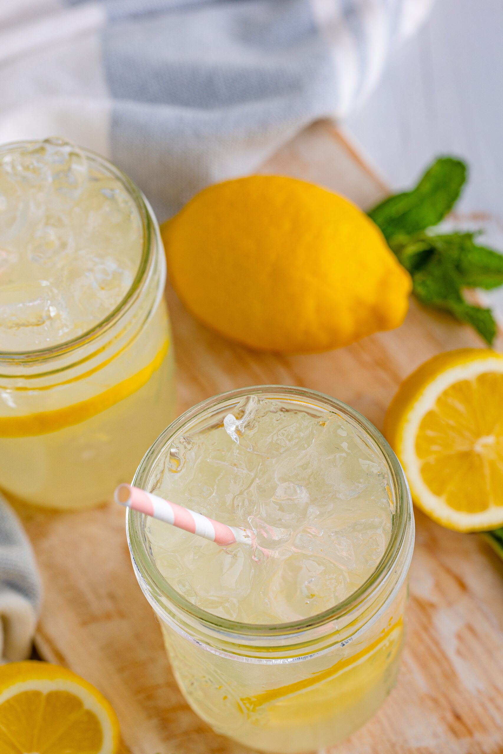 Overhead view of Homemade Lemonade in two mason jars garnished with lemon slices.