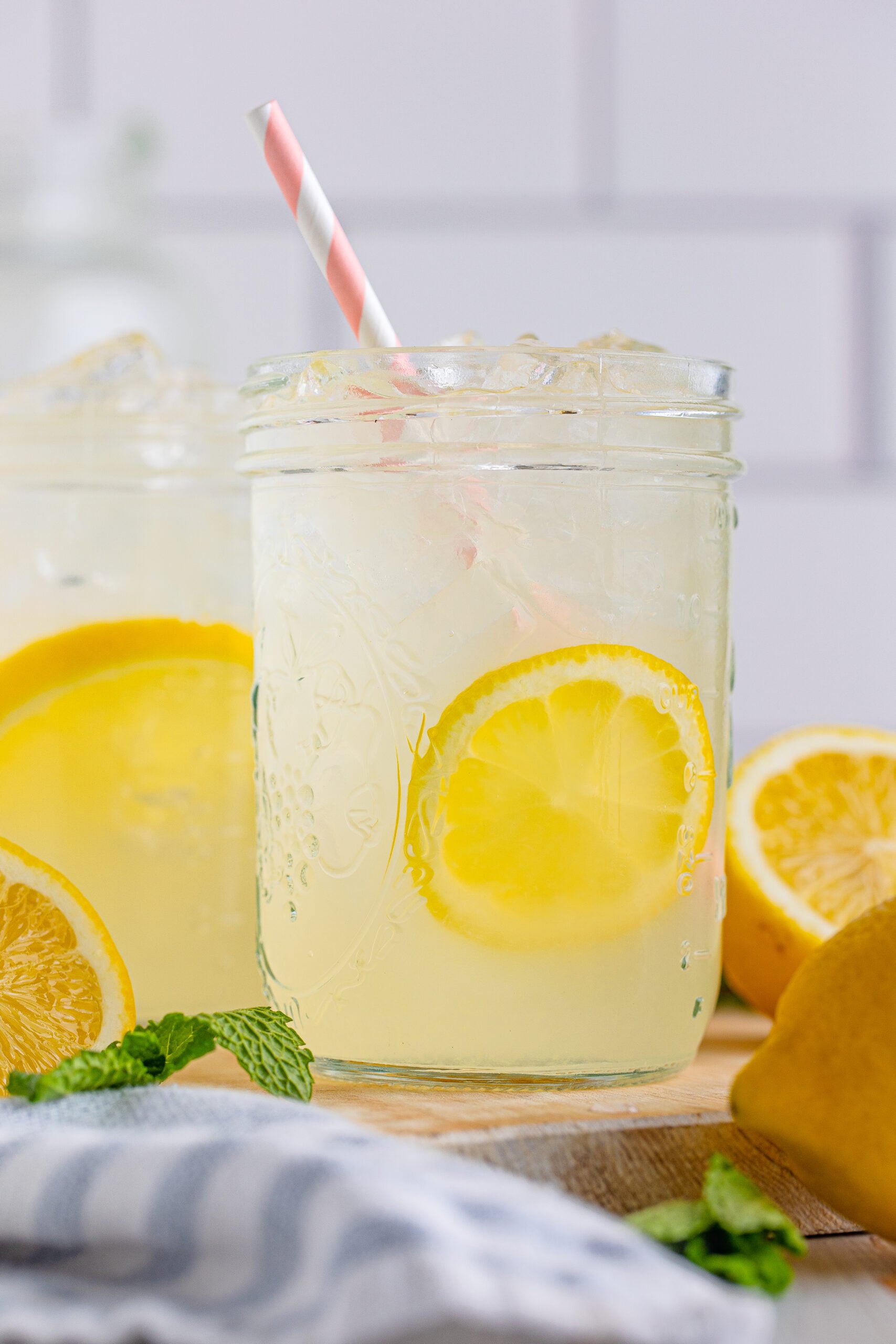 Close up view of Homemade Lemonade in two mason jars garnished with lemon slices.