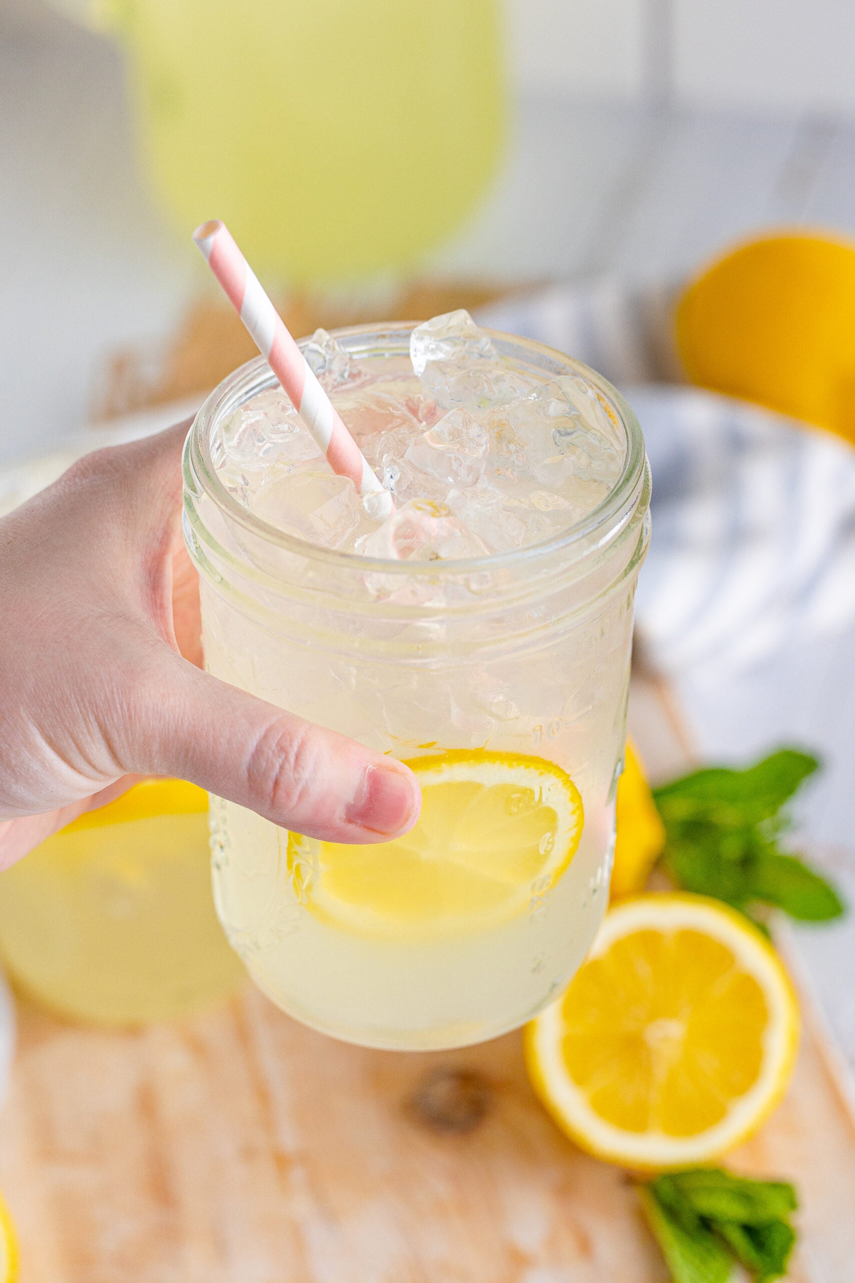 Front view of Homemade Lemonade in two mason jars garnished with lemon slices.