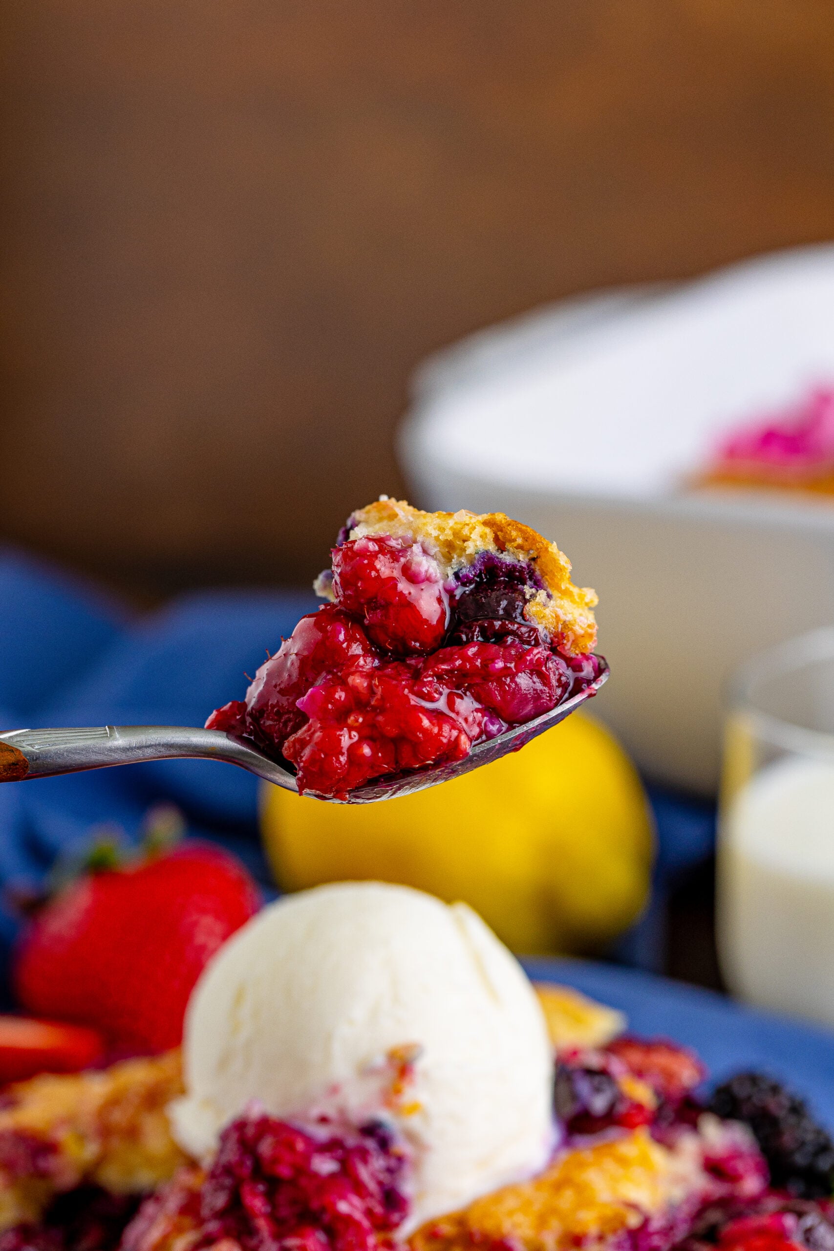 Front view of a bite of Mixed Berry Cobbler on a silver spoon.
