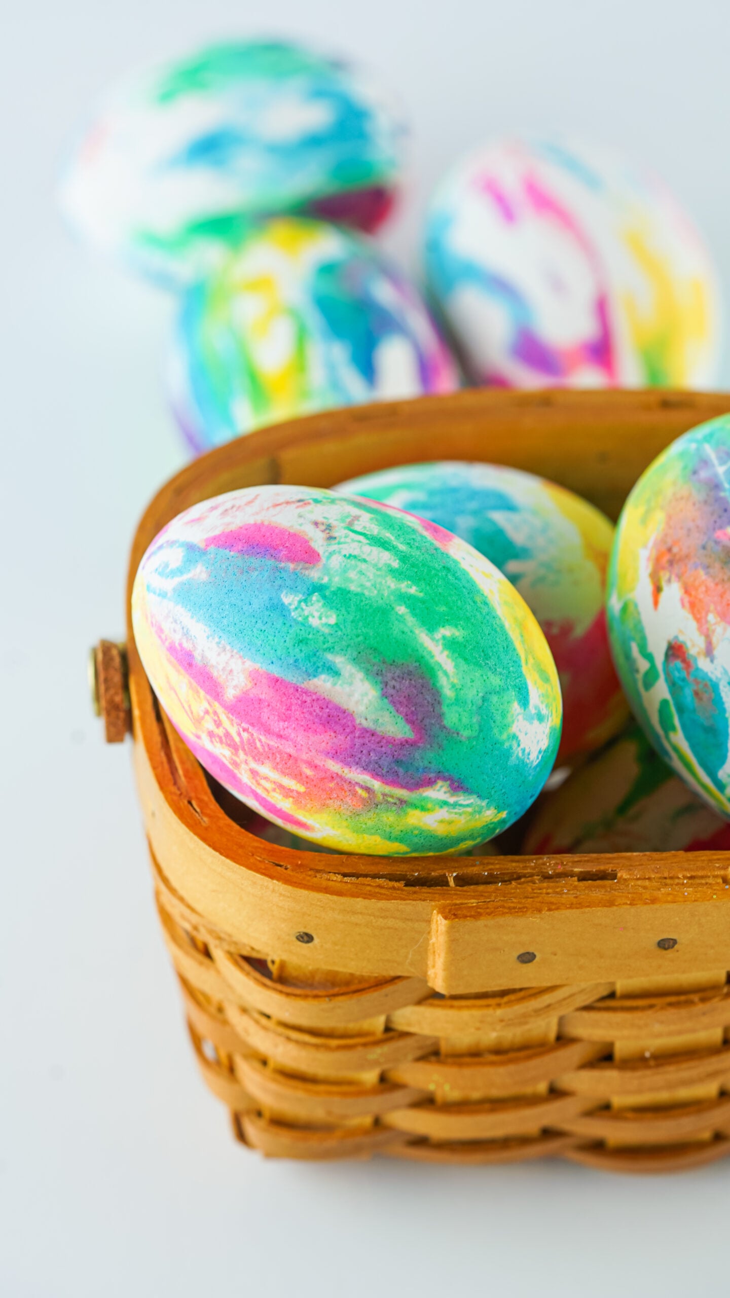 Close up view of Tie Dye Easter Eggs in a brown basket.