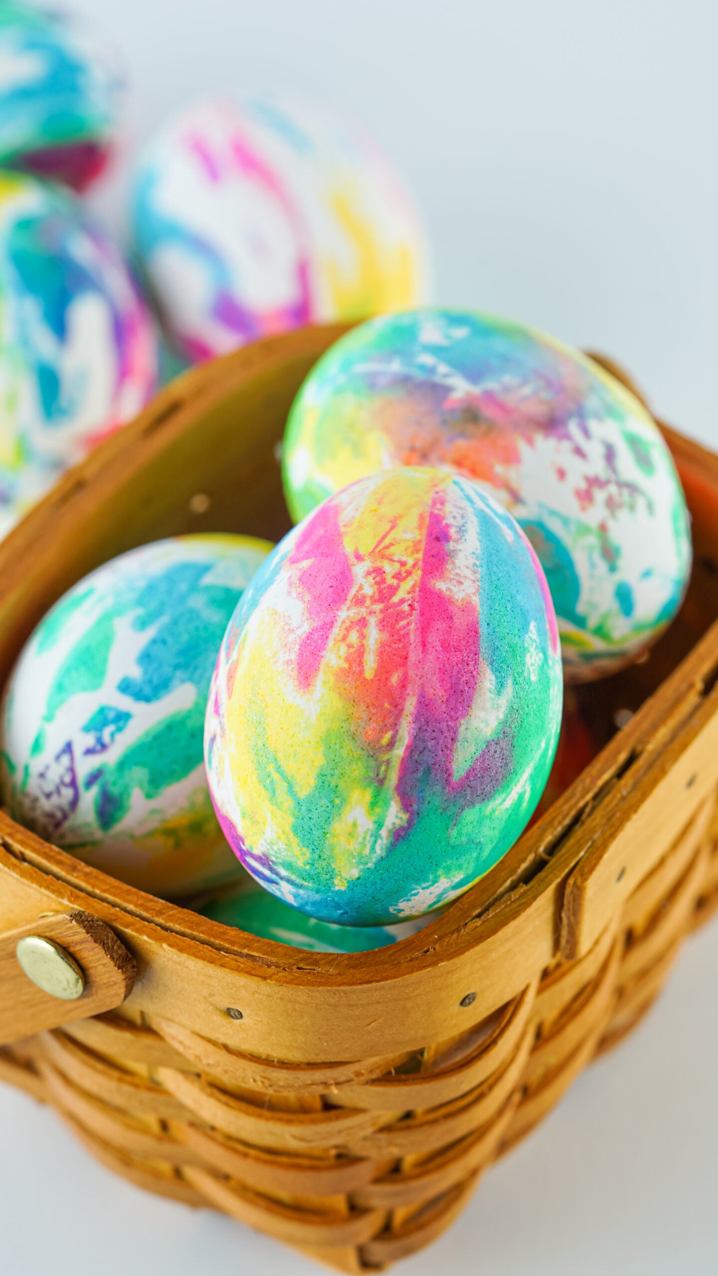 Close up view of Tie Dye Easter Eggs in a brown basket.