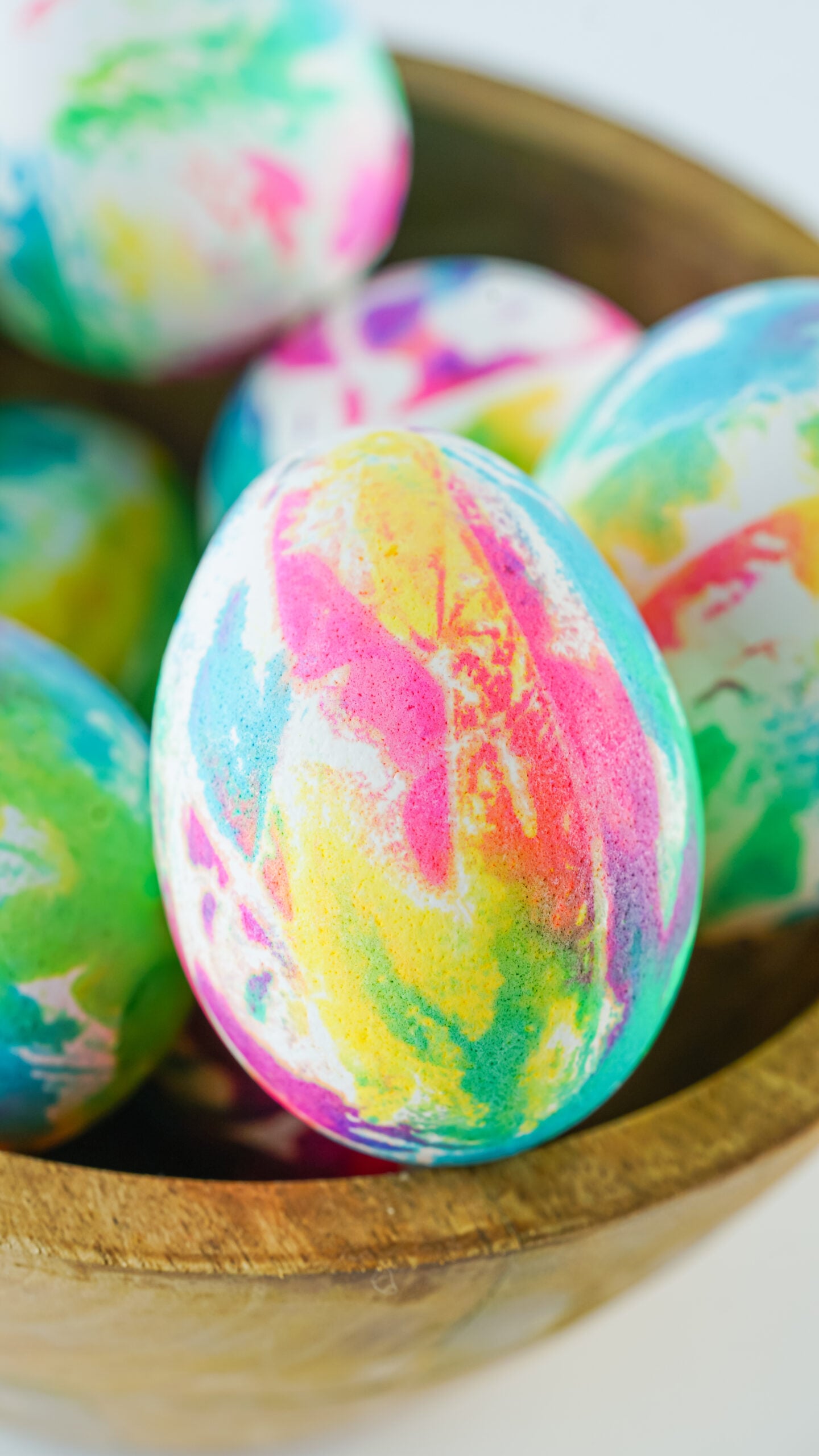 Close up view of Tie Dye Easter Eggs in a brown bowl.