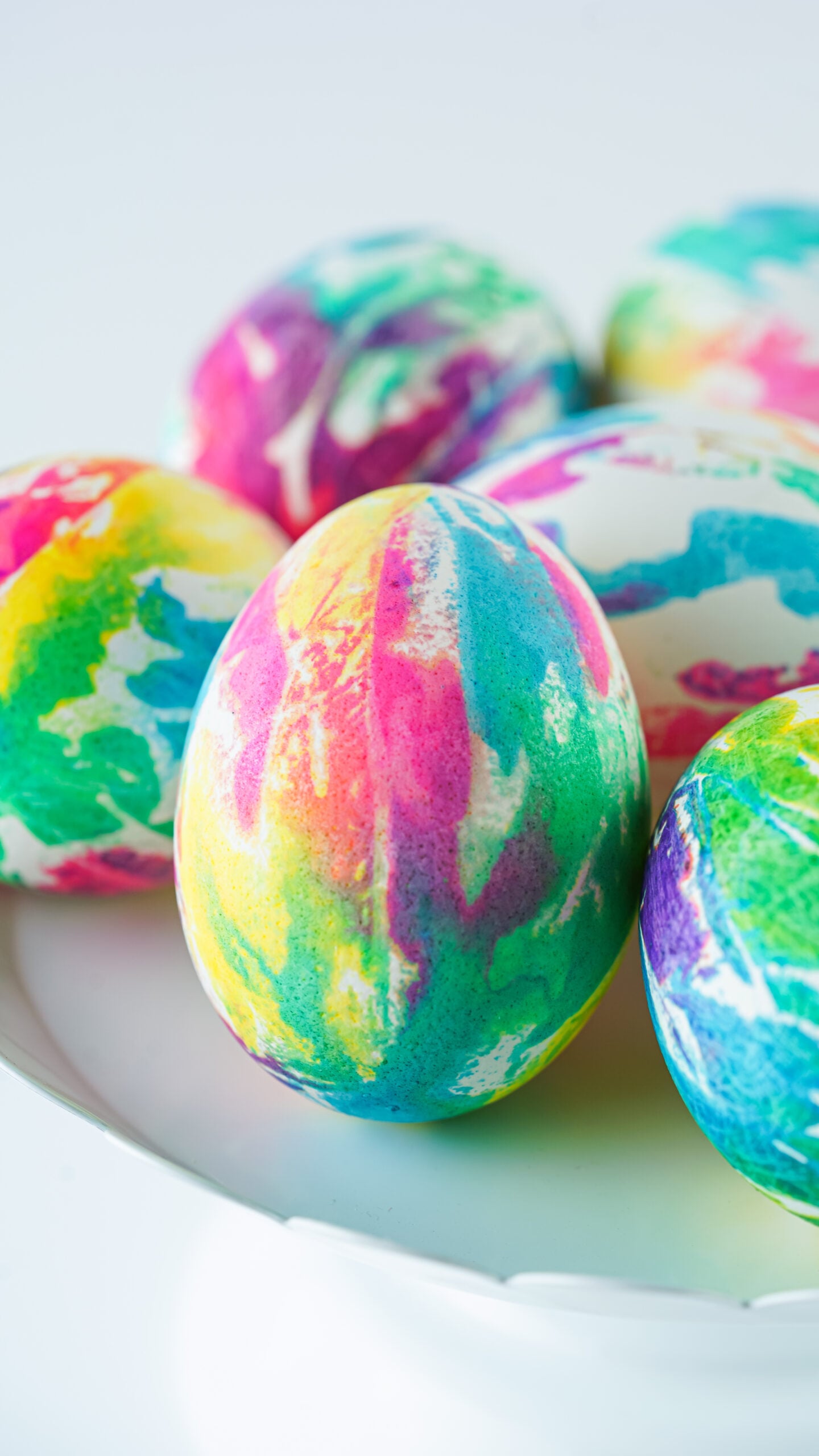Close up view of Tie Dye Easter Eggs on a white stand.