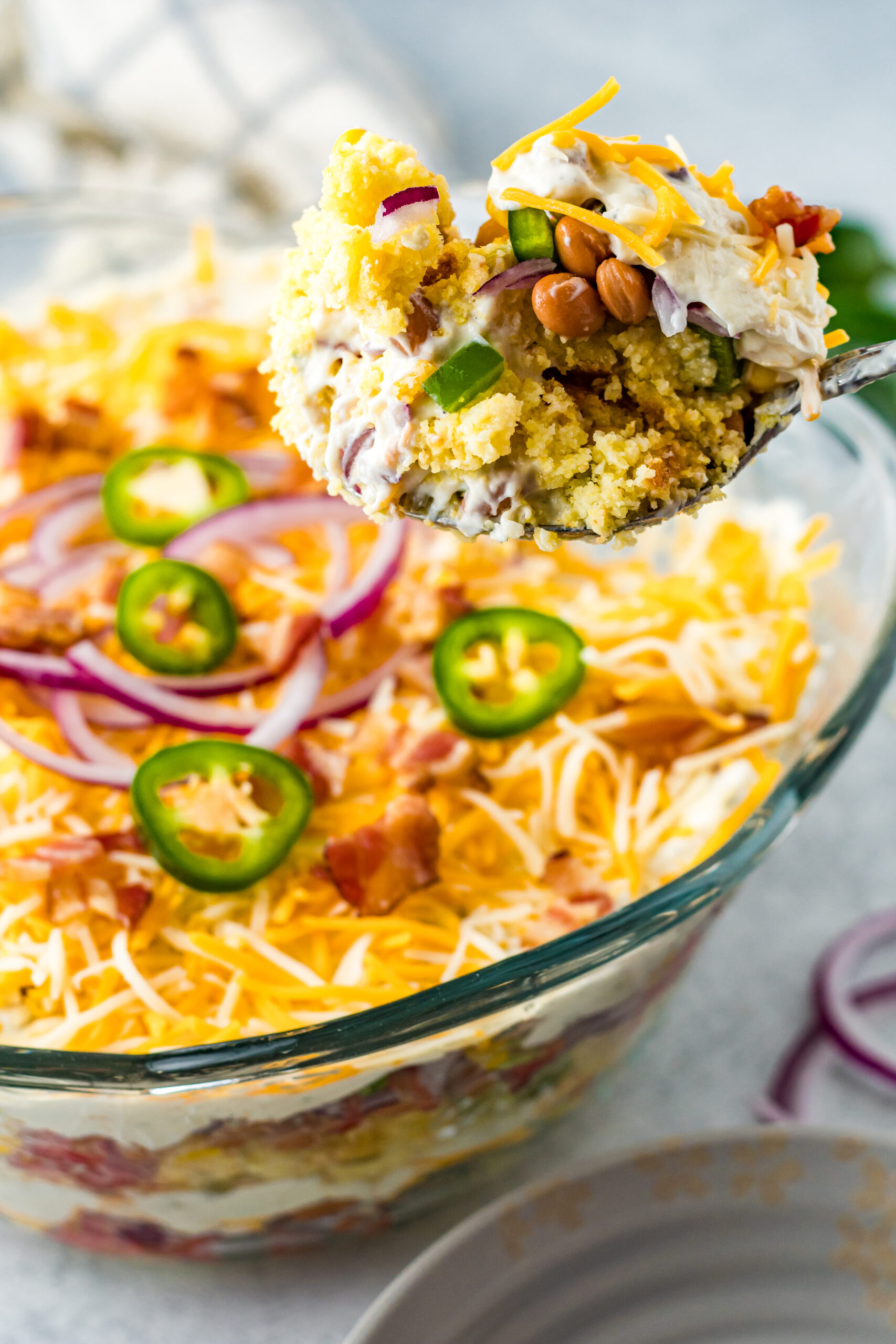 Front view of a serving of Cornbread Salad on a silver serving spoon.