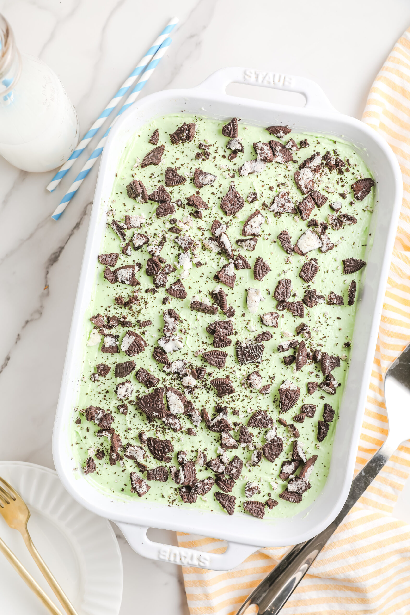 Overhead view of the Shamrock Lasagna in a white baking dish topped with crushed Oreos.