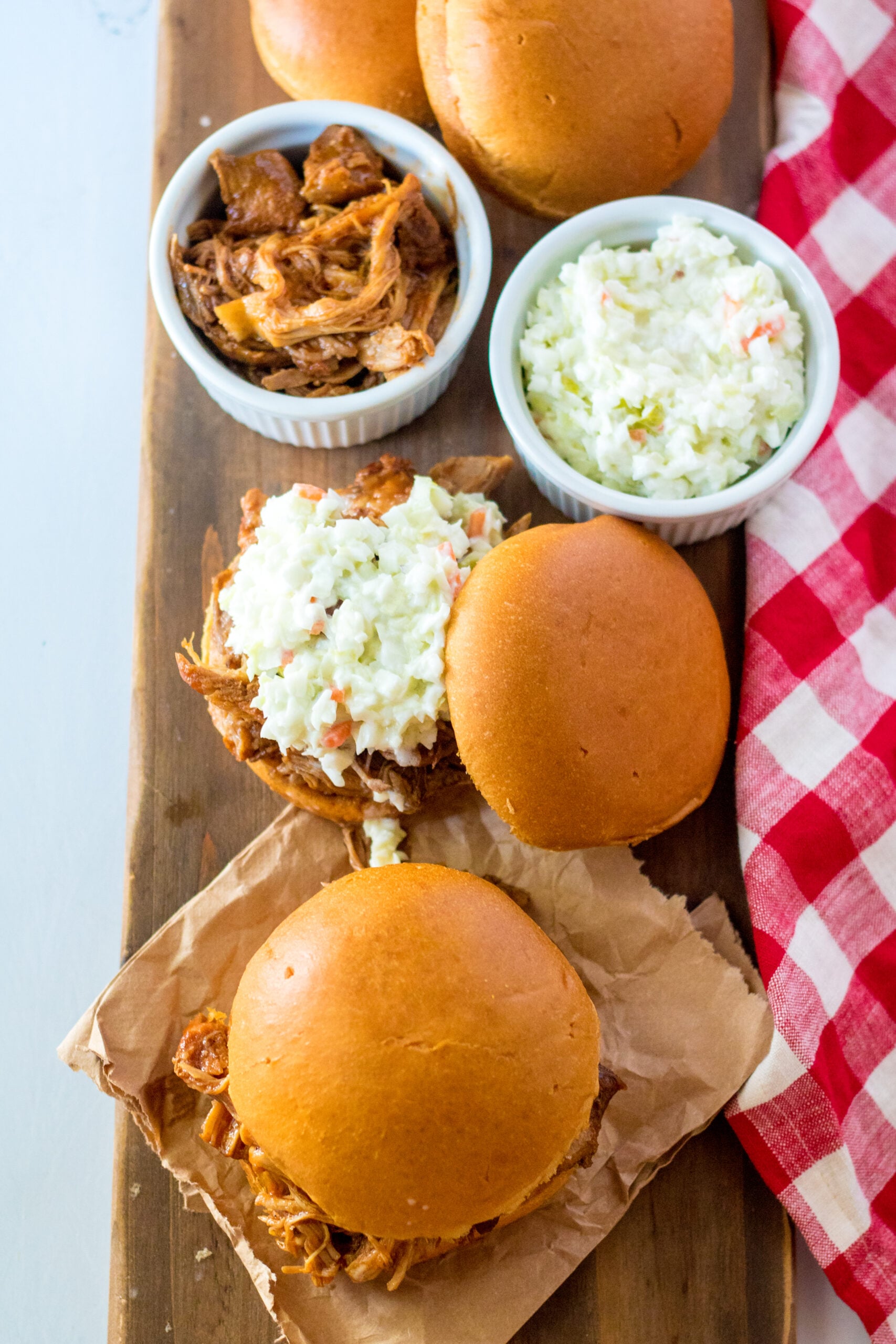 Overhead view of Slow Cooker Cola Pulled Pork on a bun served with coleslaw.