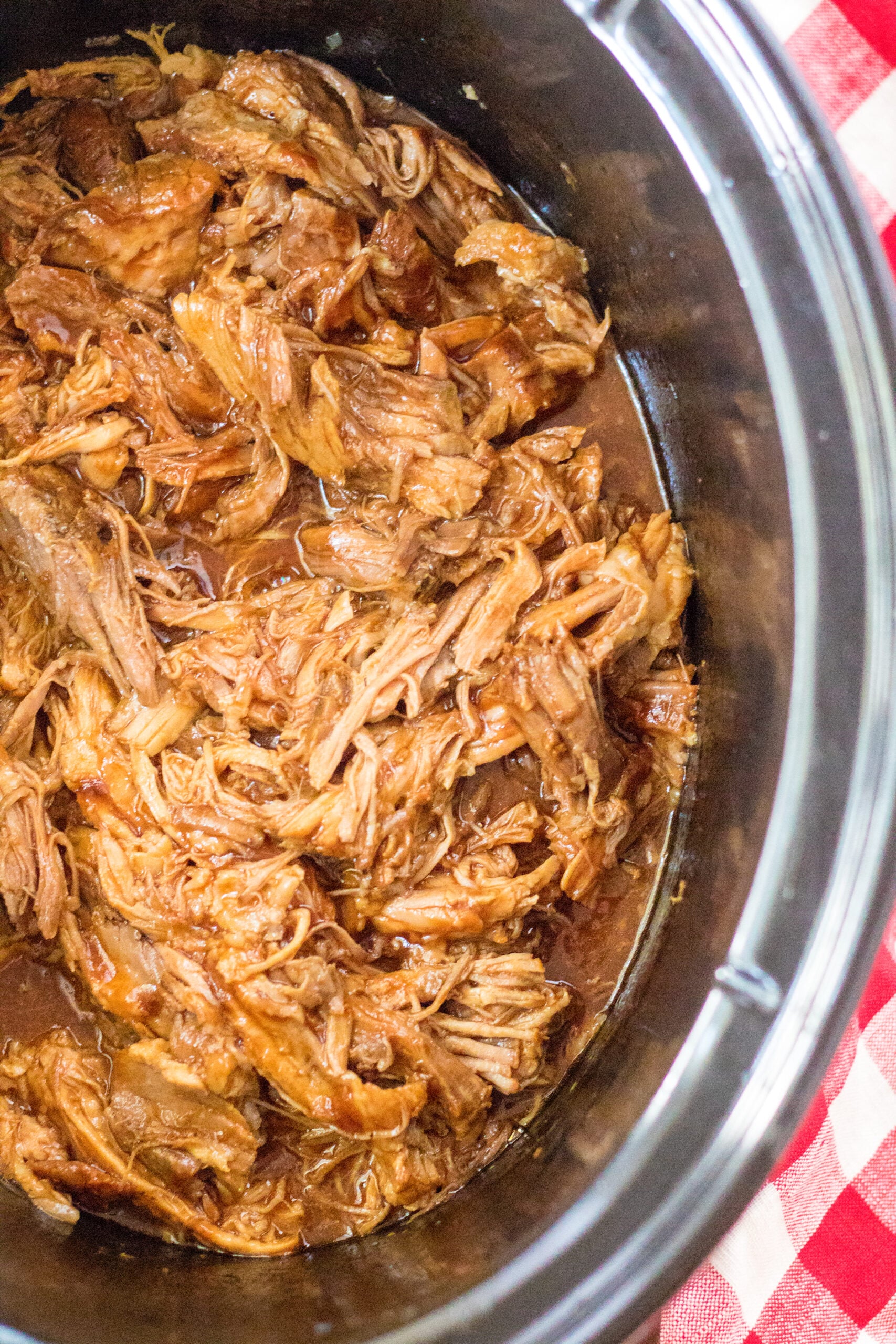 Close up view of Slow Cooker Cola Pulled Pork in a crock pot.