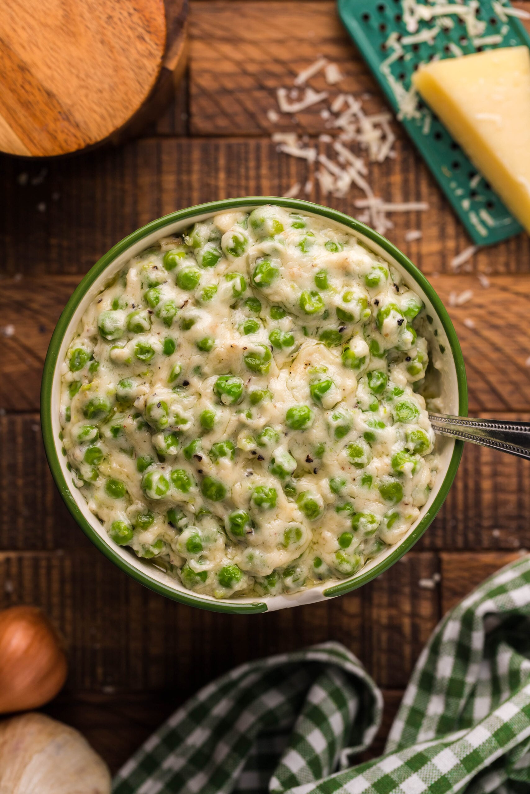 Overhead shot of creamed peas in a green and white bowl. 