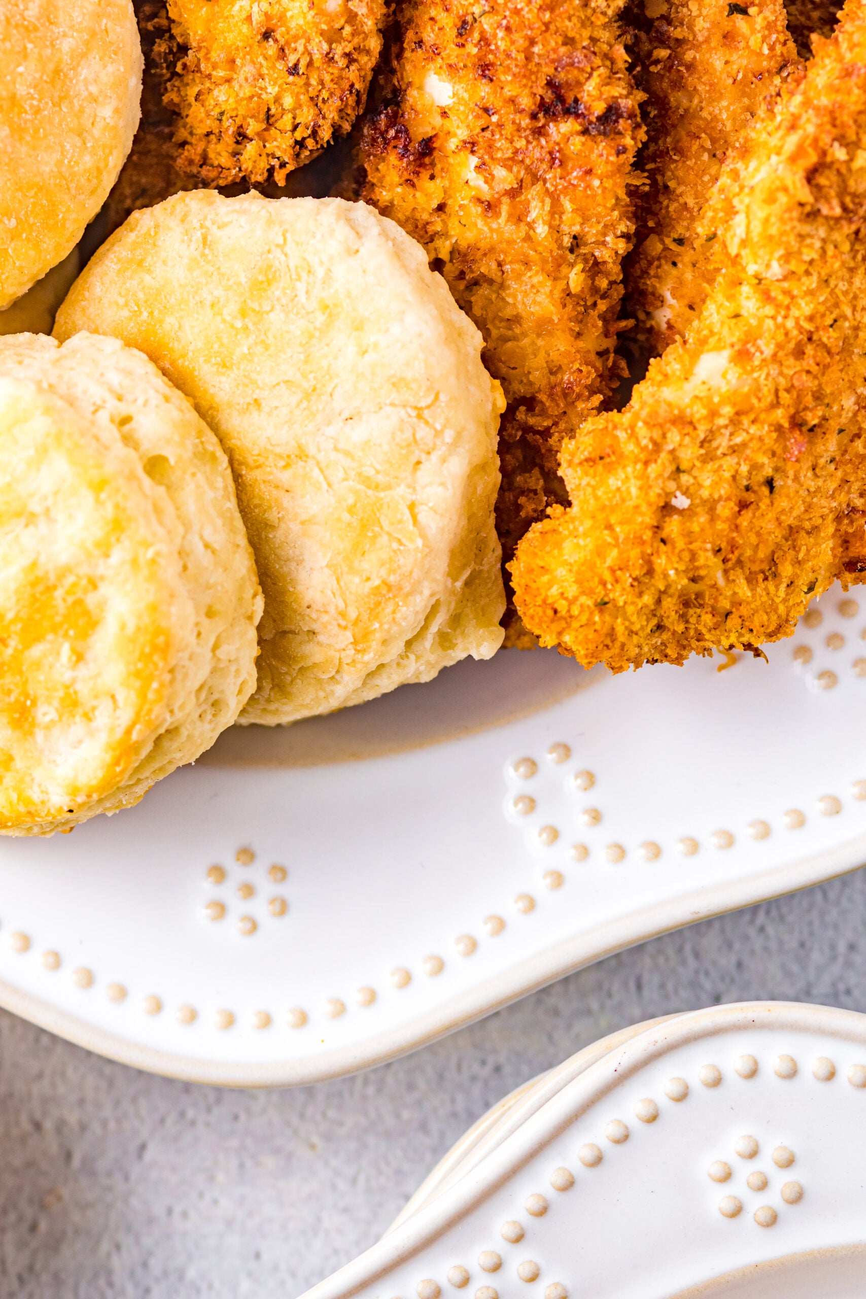 Close up view of Honey Butter Chicken Biscuit unassembled on a white dish.