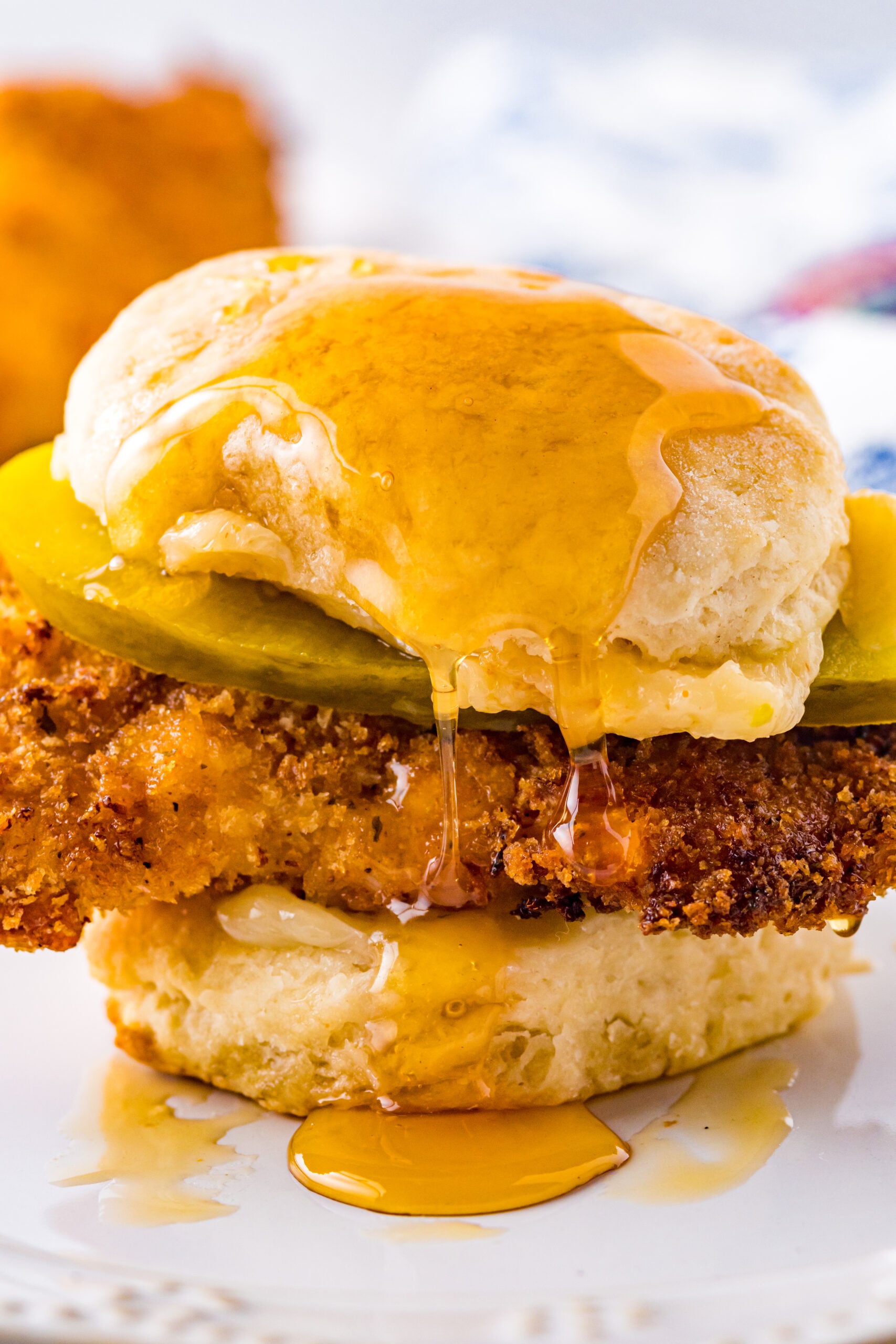 Front view of Honey Butter Chicken Biscuit on a white plate.