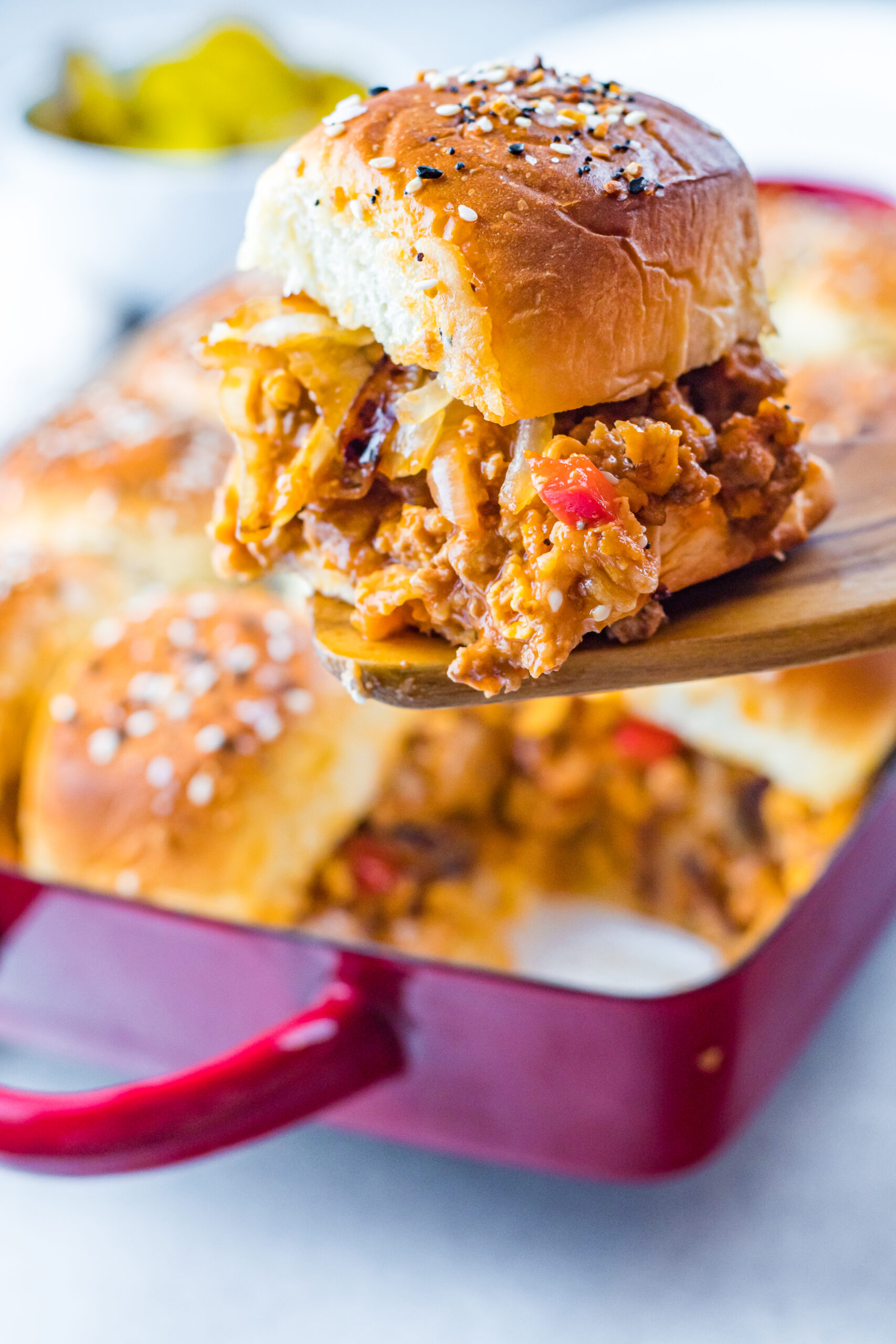 Front view of a Cheesy Chicken Sloppy Joe Slider on a wooden spatula.