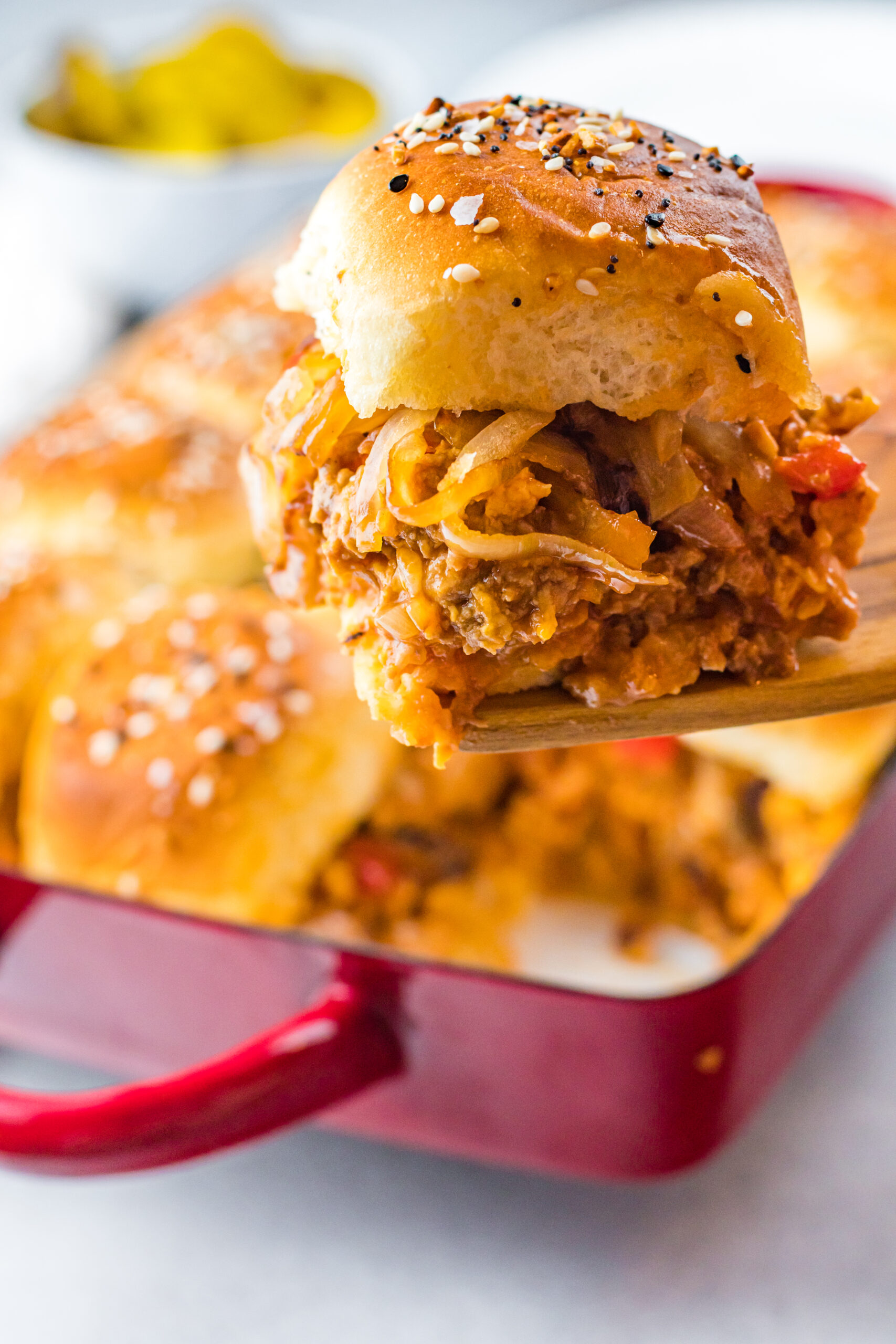 Front view of a Cheesy Chicken Sloppy Joe Slider on a wooden spatula.