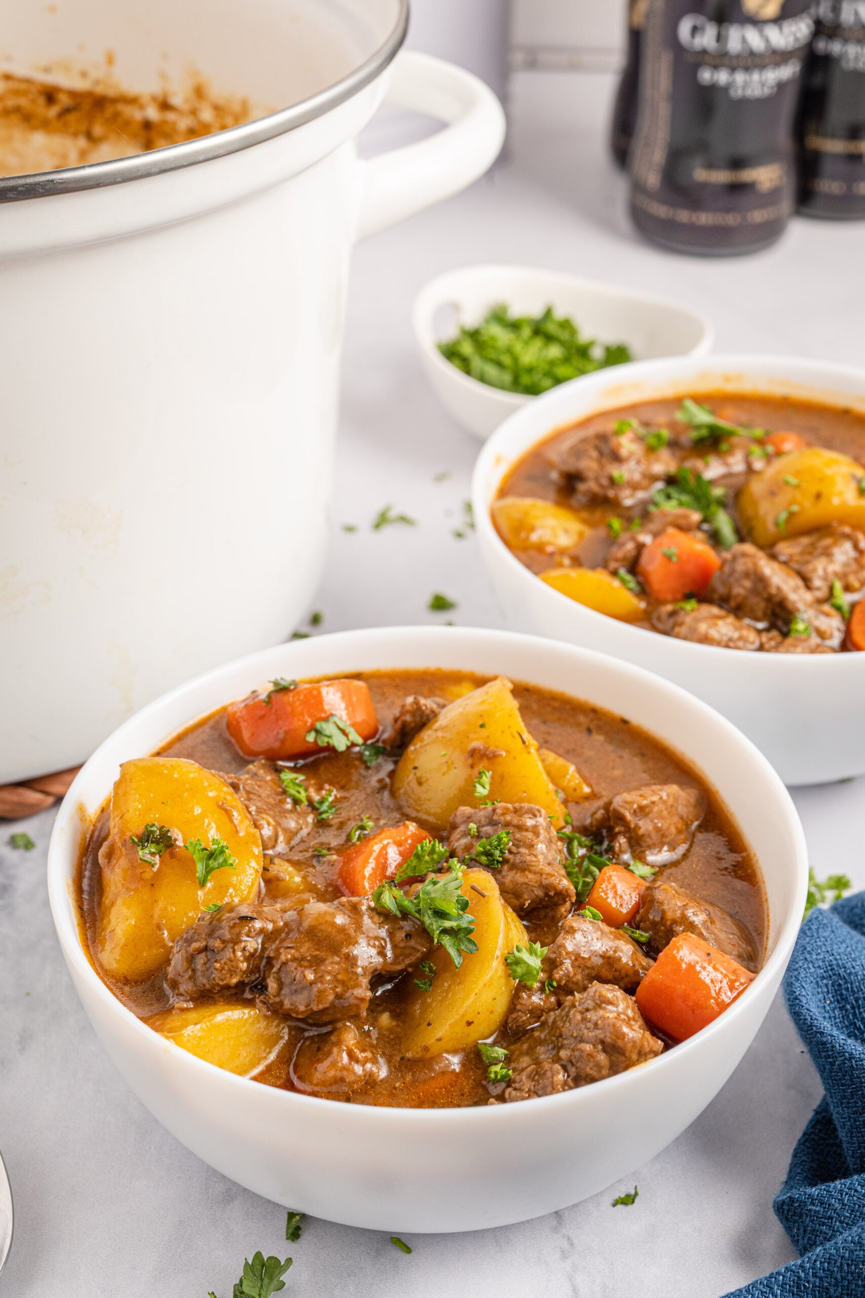 Two bowls of Irish Stew topped with fresh parsley leaves.