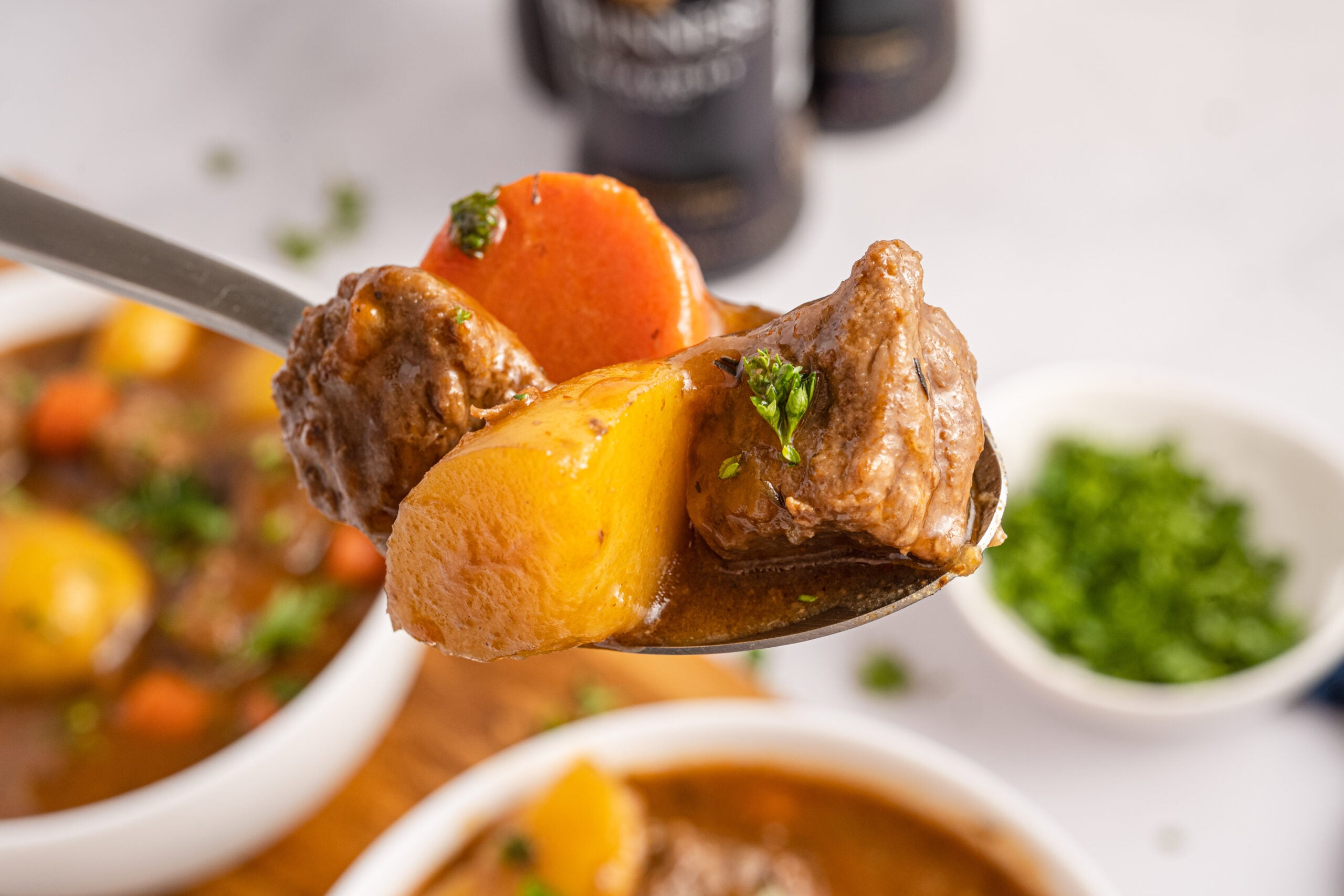 Two bowls of Irish stew with a spoon lifting up a bite