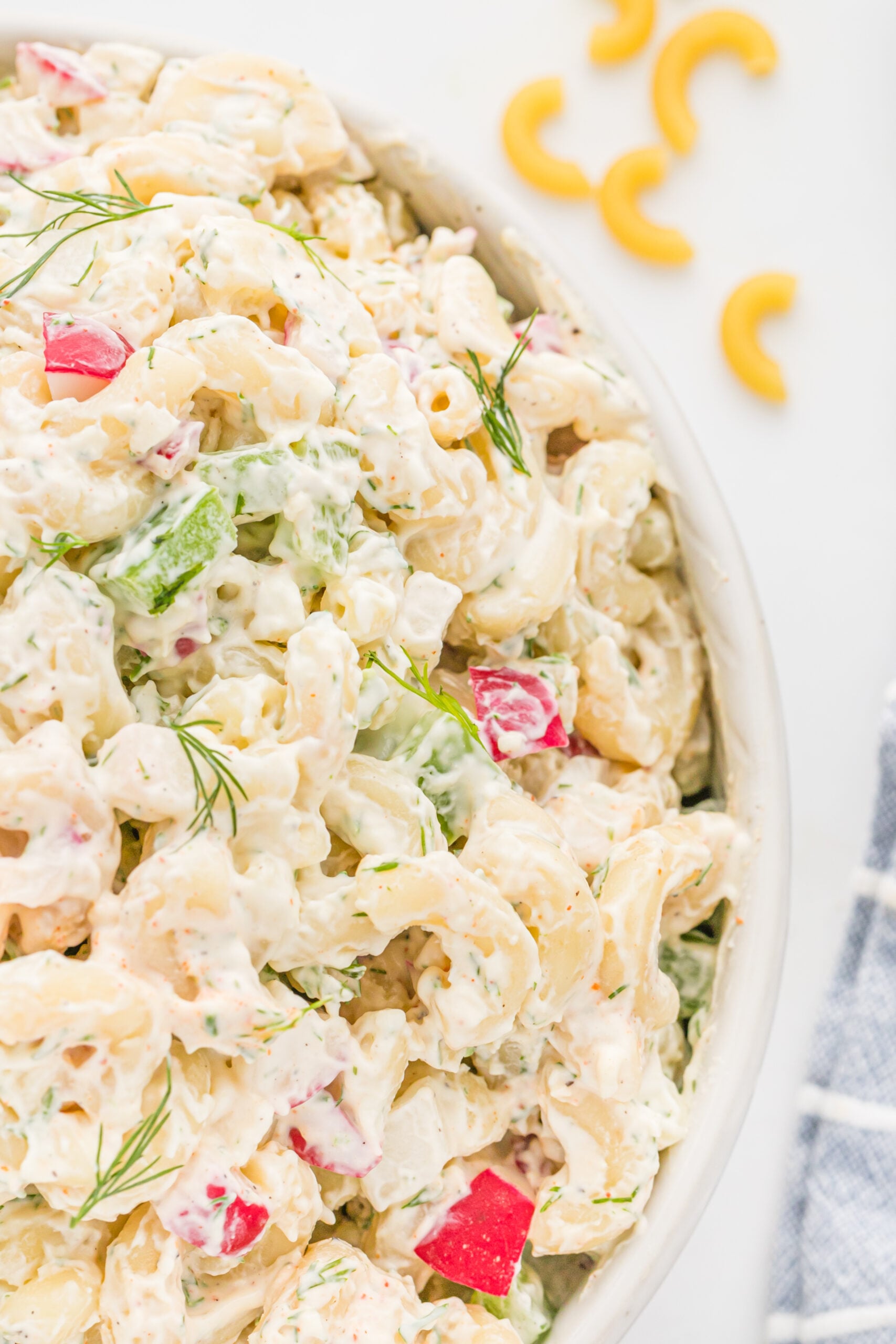 Close up view of Macaroni Dill Pasta Salad in a white serving bowl.