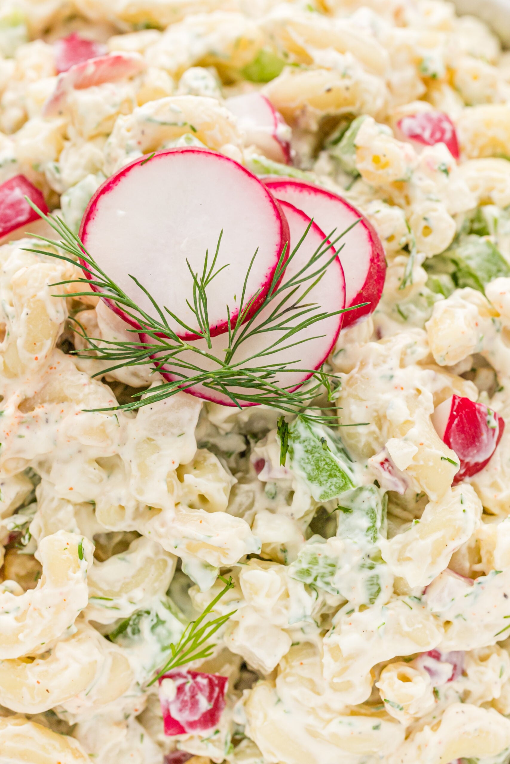 Close up view of Macaroni Dill Pasta Salad in a white serving bowl.