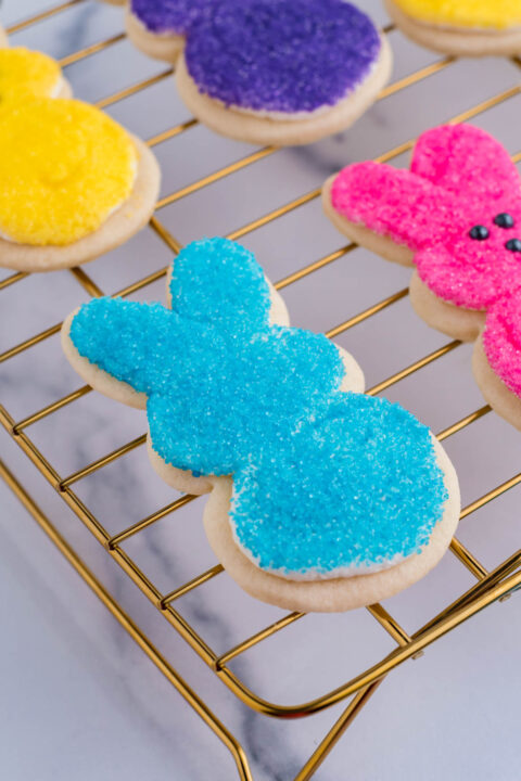 An Easter bunny cookie after being dipped in blue sprinkles.